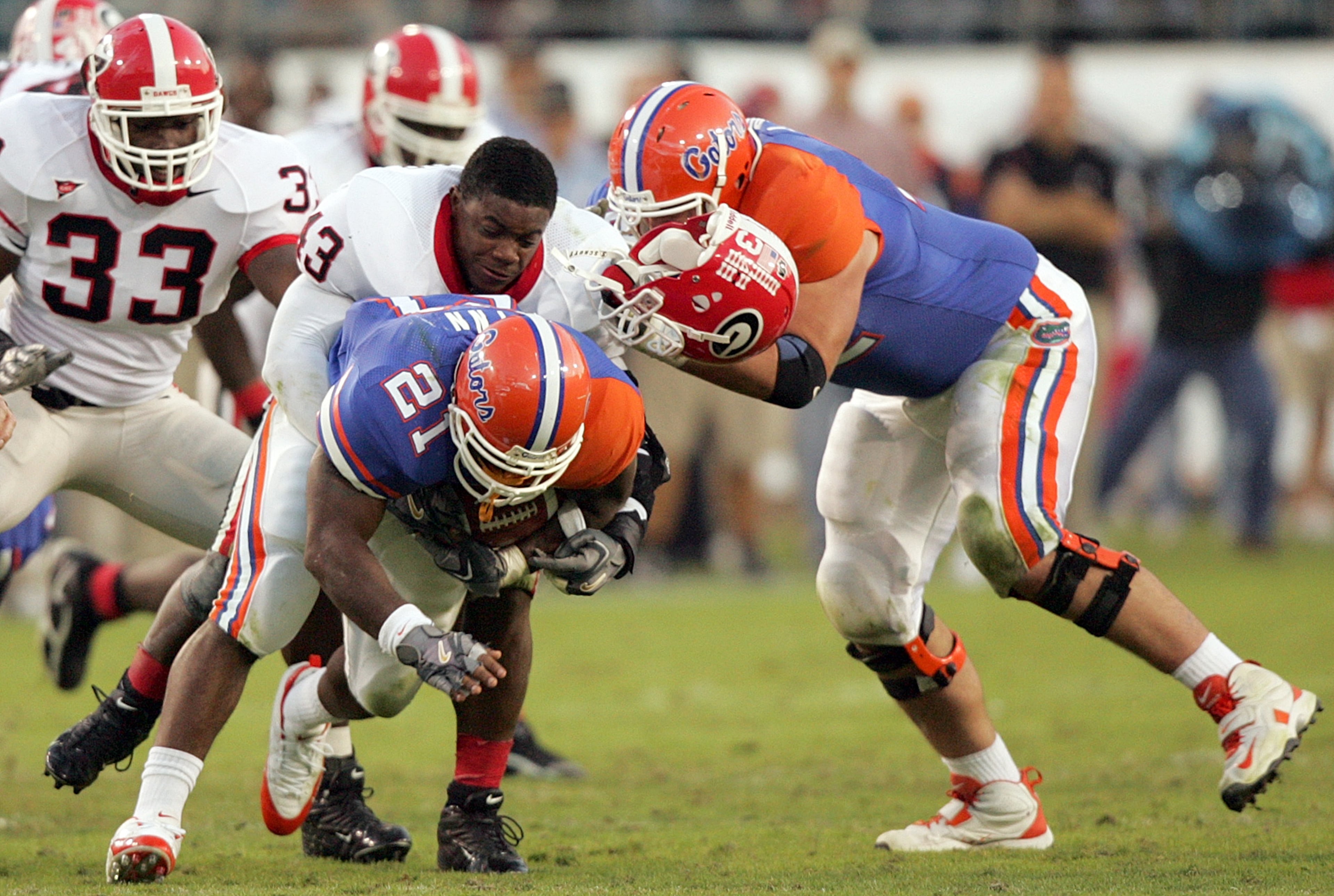 UGA linebacker Tony Taylor (43) loses his helmet on the tackle of Gator running back DeShawn Wynn (21) in 2005.