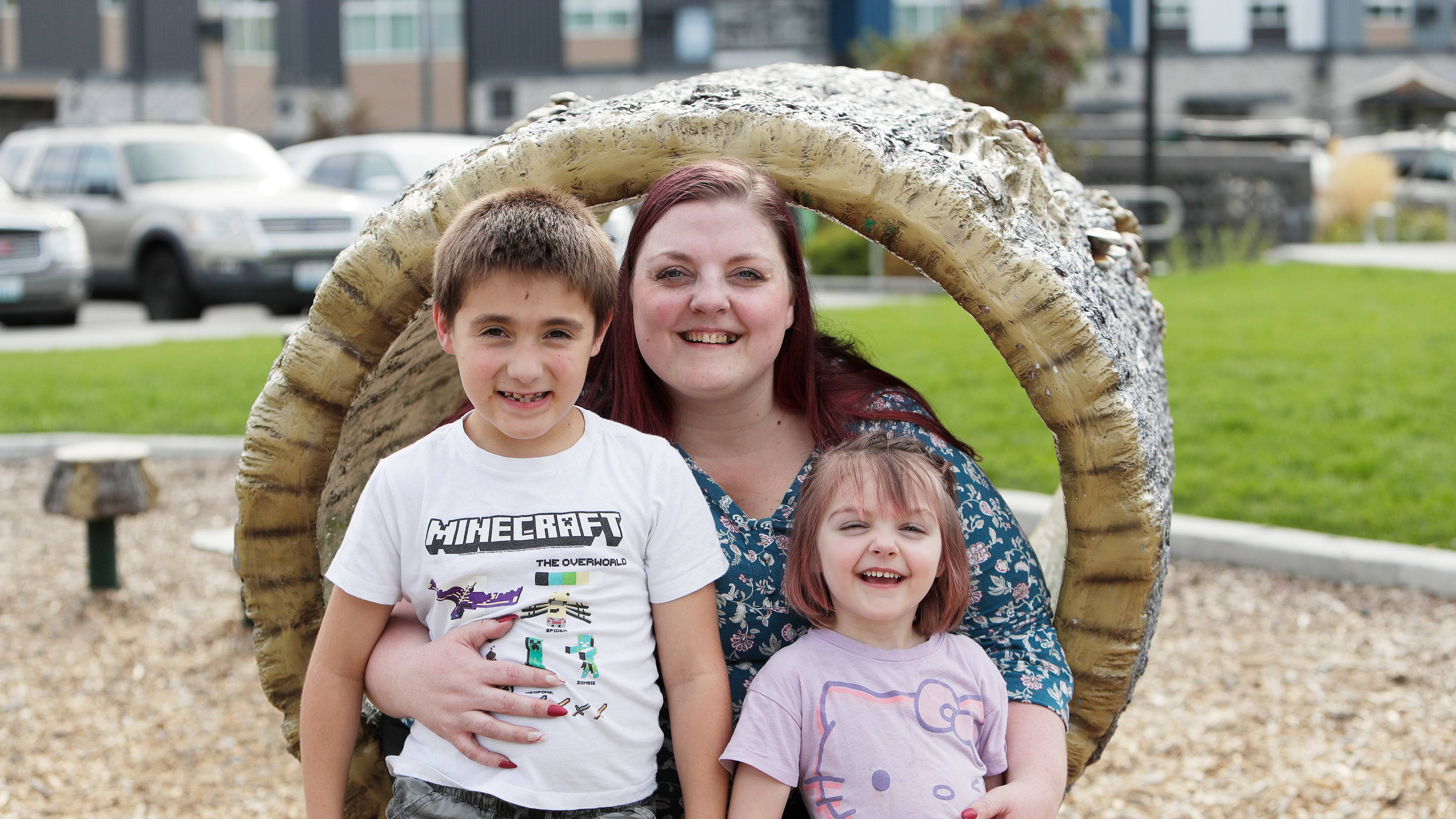 Cassie Reed, center, sits for a photograph with her son Kian Reed, left, and daughter Evie Reed outside their apartment building, Tuesday, Sept. 22, 2026, in Spokane, Wash. (AP Photo/Young Kwak)