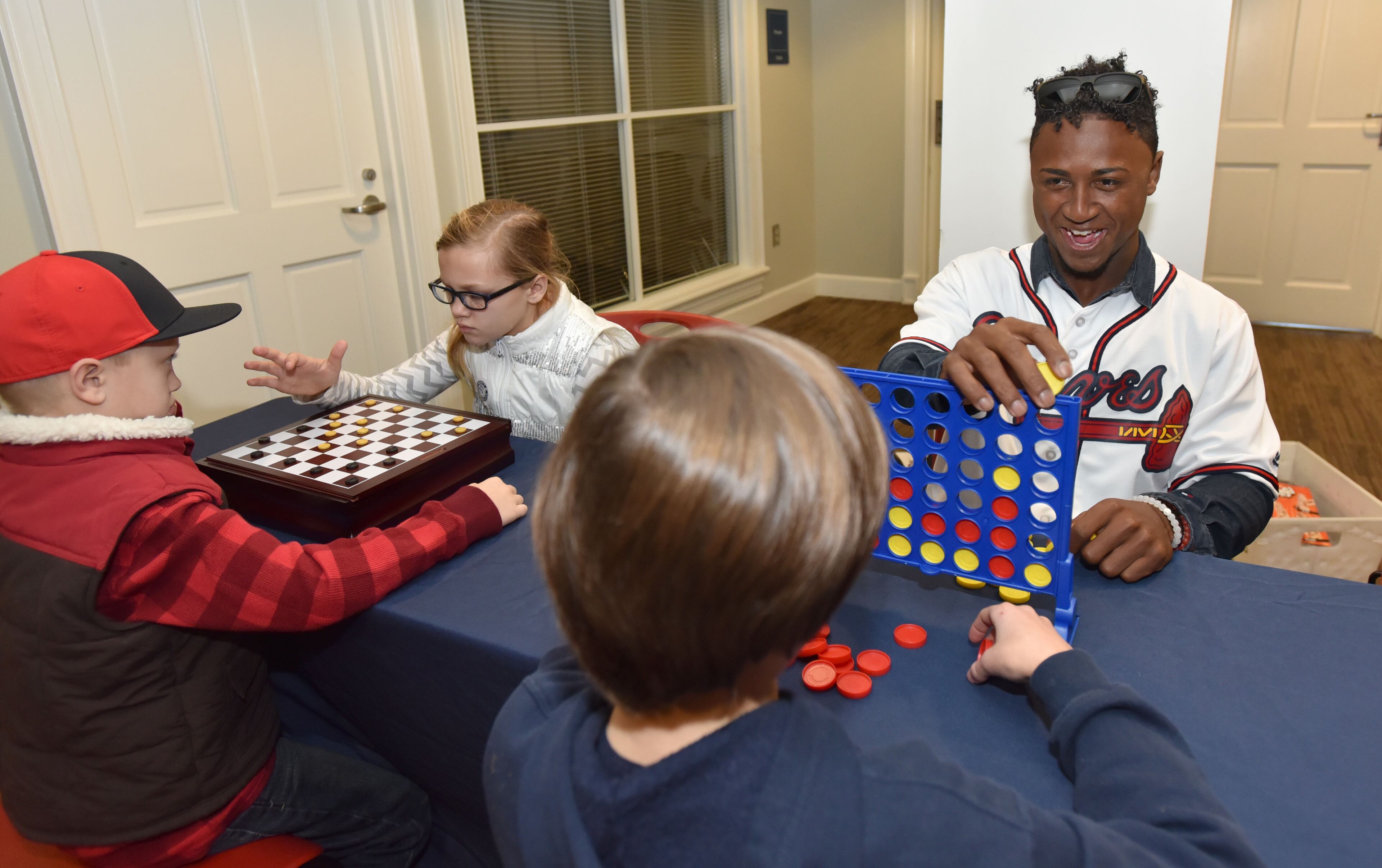 Atlanta Braves Ozzie Albies (right) plays Connect Four with Zackery Gurley (foreground), 12, during 2016 Atlanta Braves Fan Fest at Turner Field on Saturday, January 30, 2016. In celebration of the Final Season at Turner Field, the Atlanta Braves hosted a FanFest at the ballpark. The day included autograph sessions, tours, photo stations and more, and kicks off the final season at Turner Field. HYOSUB SHIN / HSHIN@AJC.COM