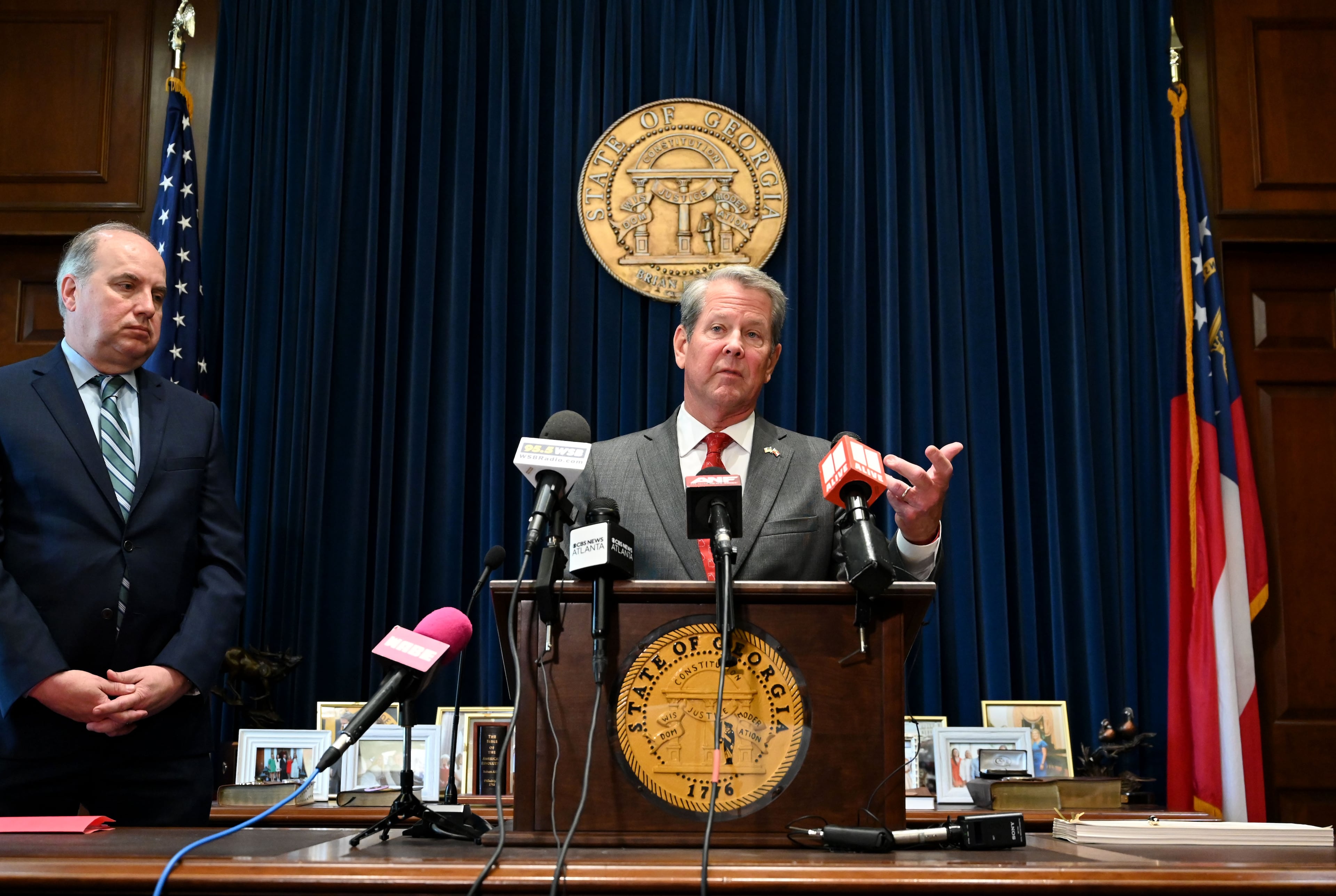 Gov. Brian Kemp (center) speaks before signing the state's new budget on Tuesday alongside Rick Dunn (left), director of the Governor's Office of Planning and Budget. (Hyosub Shin/AJC)