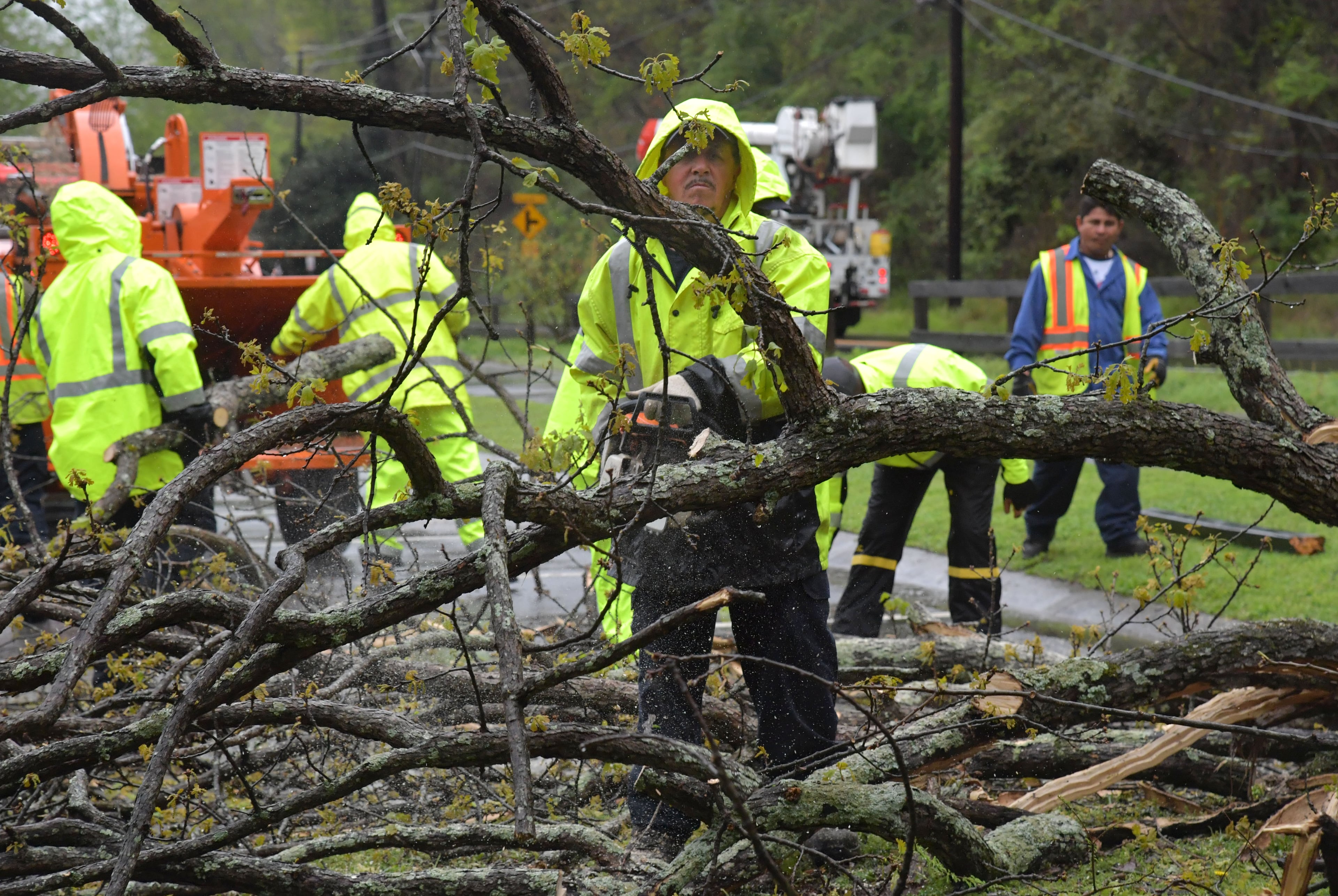 April 5, 2017 Roswell - Crew members clean up fallen trees on Azalea Drive near Avia Riverside Apartments in Roswell on Wednesday, April 5, 2017. The threat of severe weather has resulted in multiple cancellations and delays. Thousands of outages across metro Atlanta during weather advisory. HYOSUB SHIN / HSHIN@AJC.COM