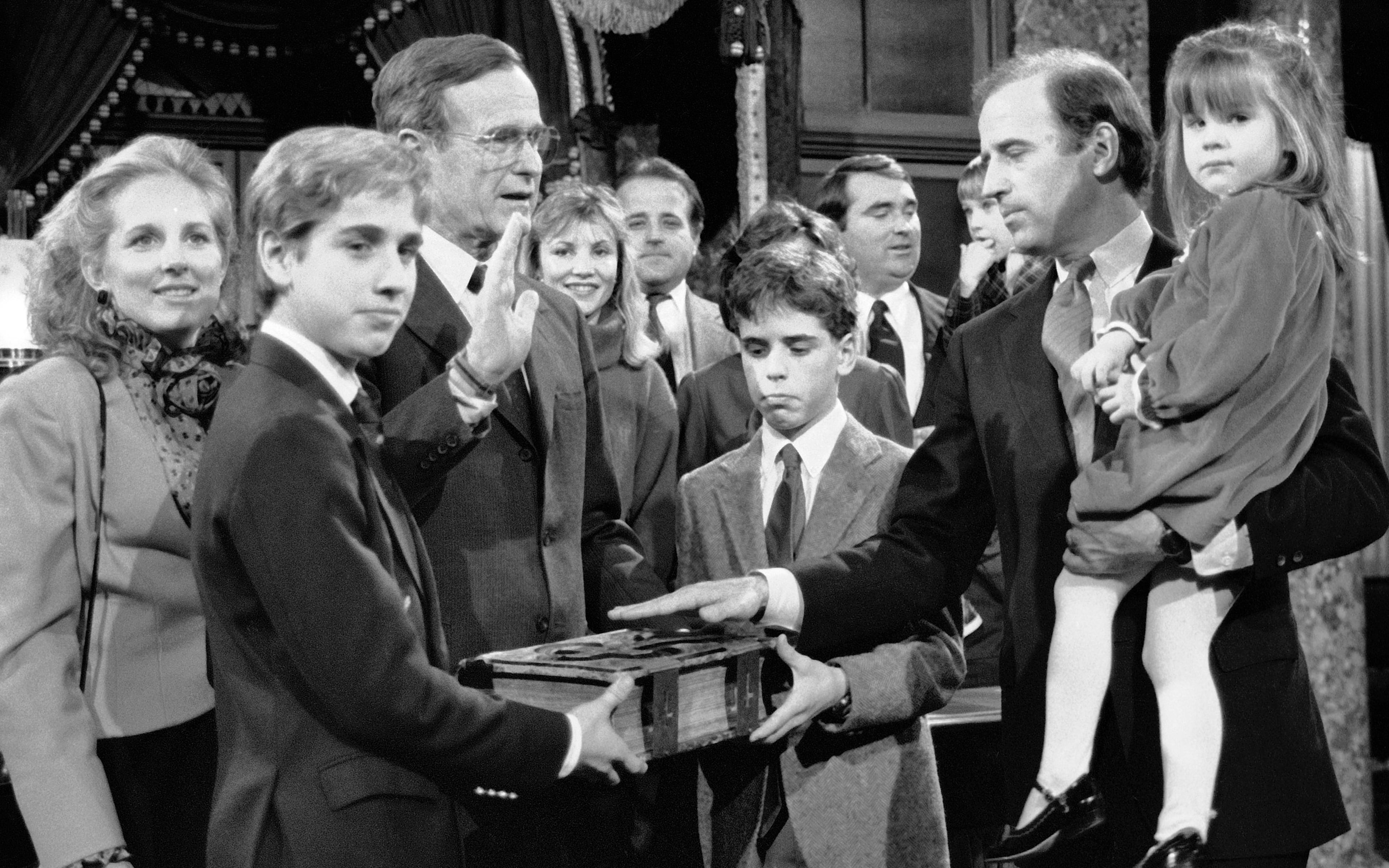 In this Jan. 3, 1985, file photo, Sen. Joe Biden (D-Del.) holds his daughter, Ashley, while taking a re-enacted oath of office from Vice President George Bush during a ceremony on Capitol Hill in Washington as his sons Beau, foreground, and Hunter hold the bible. On May 30, 2015, Vice President Joe Biden announced the death of son, Beau, from brain cancer.