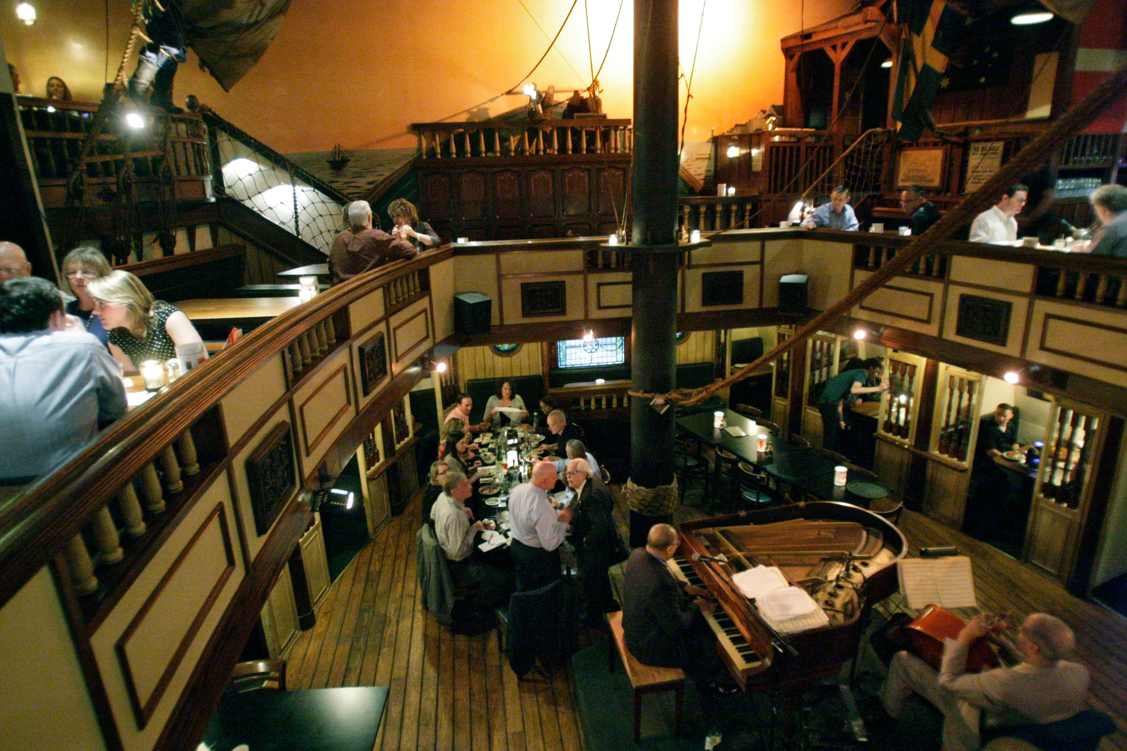 Dante (at the table, center-left) talks with guests on the sailing ship's deck. He originally dreamed of a place that offered "intelligent jazz" and an atmosphere conducive to proposals and prom dates. After 43 years, "The Hatch" is scheduled to make way for new development at its location on Peachtree Road in Buckhead. Closing night is set for the end of July.