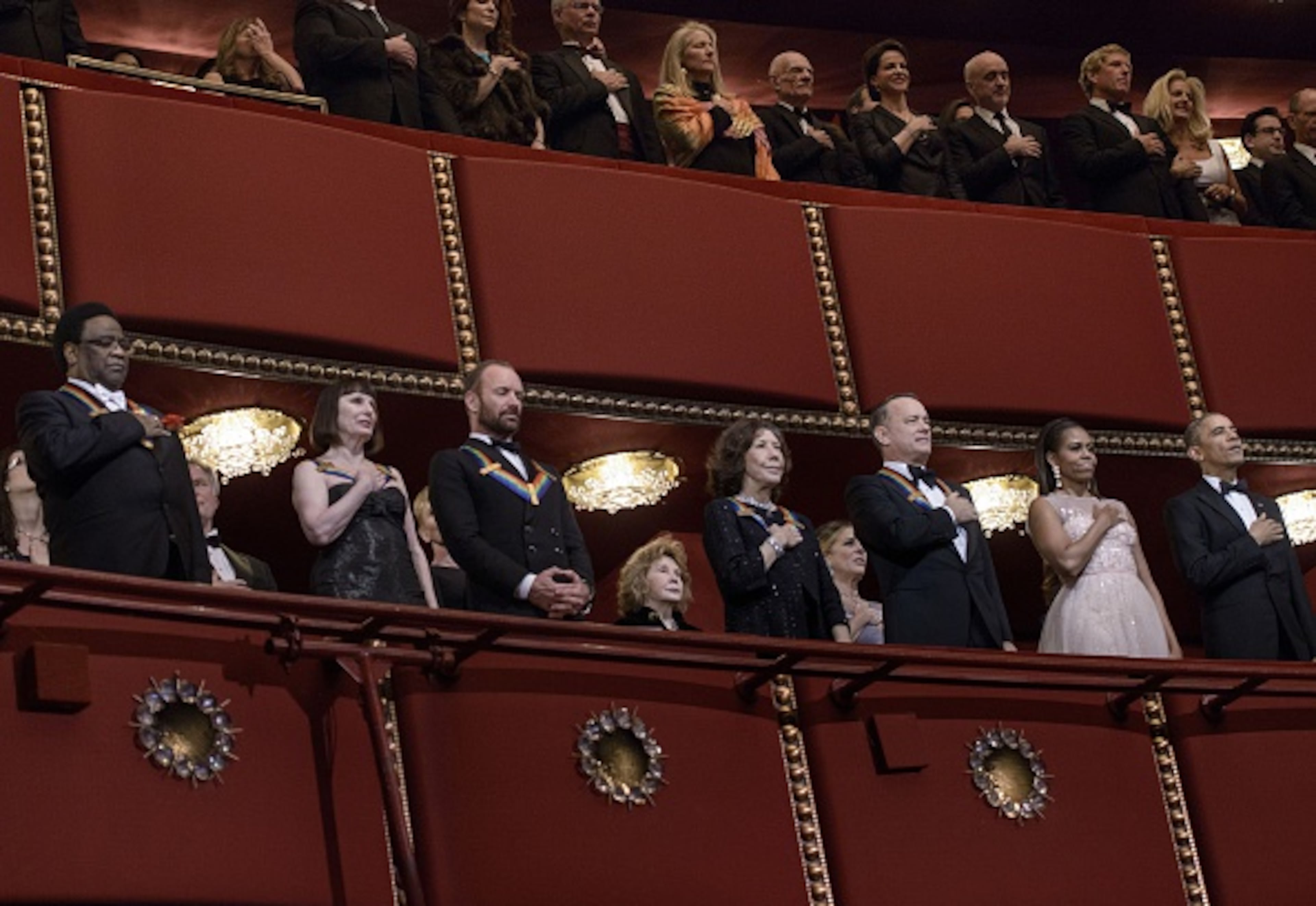 From left: musician Al Green, ballerina Patricia McBride, musician Sting, actress Lily Tomlin, actor Tom Hanks, US first lady Michelle Obama and President Barack Obama listen to the US national anthem during a taping of the 37th Kennedy Center Honors at the Kennedy Center December 7, 2014 in Washington, DC. Artists from various mediums were honored for their contribution to arts in the United States. AFP PHOTO/Brendan SMIALOWSKI (Photo credit should read BRENDAN SMIALOWSKI/AFP/Getty Images)