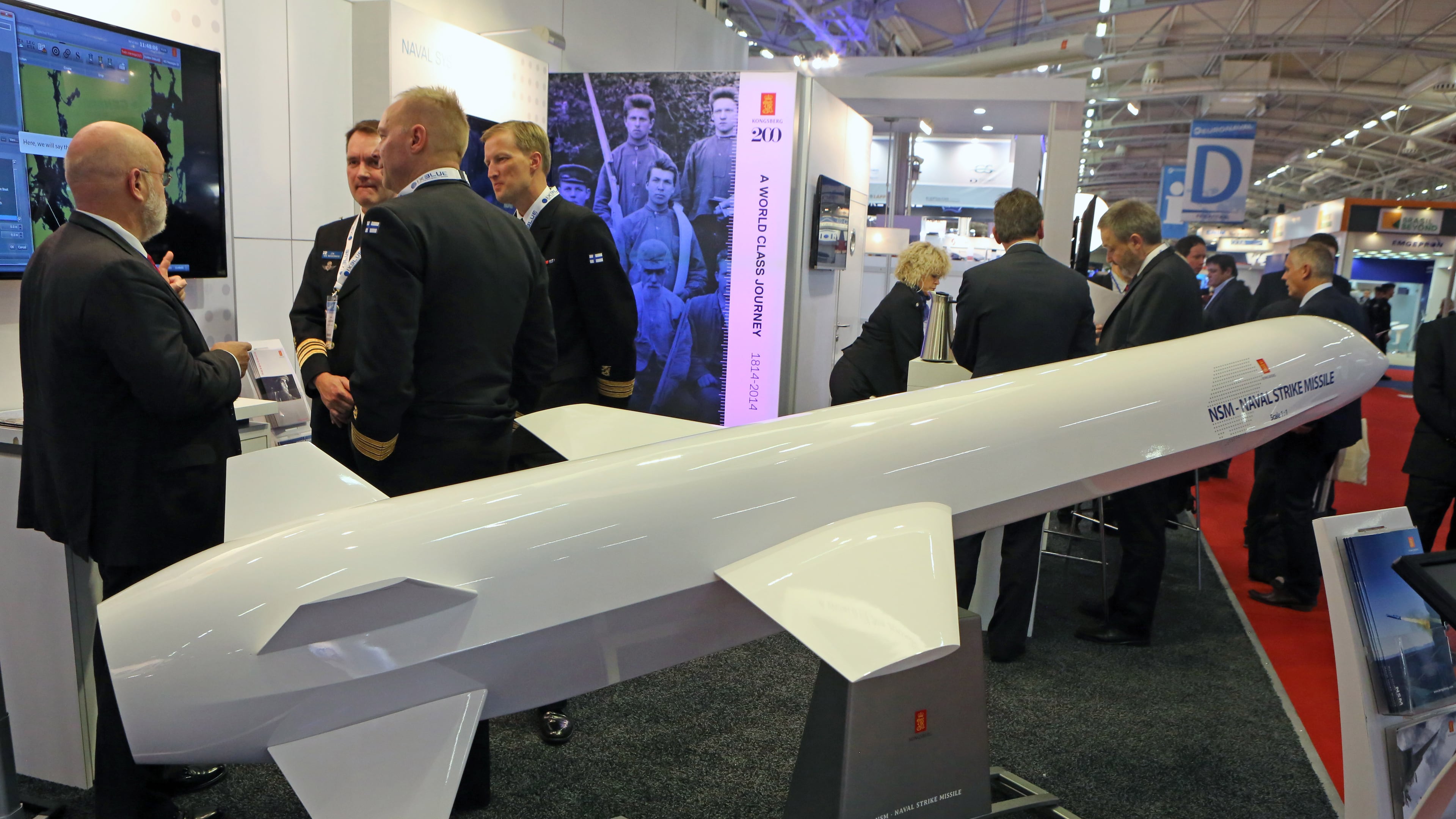 Visitors are gathered next to a display of an NSM Naval Strike Missile made by Norwegian company Kongsberg, presented at the Euronaval show, in Le Bourget, North of Paris, France, Wednesday Oct. 29, 2014. (AP Photo/Remy de la Mauviniere)