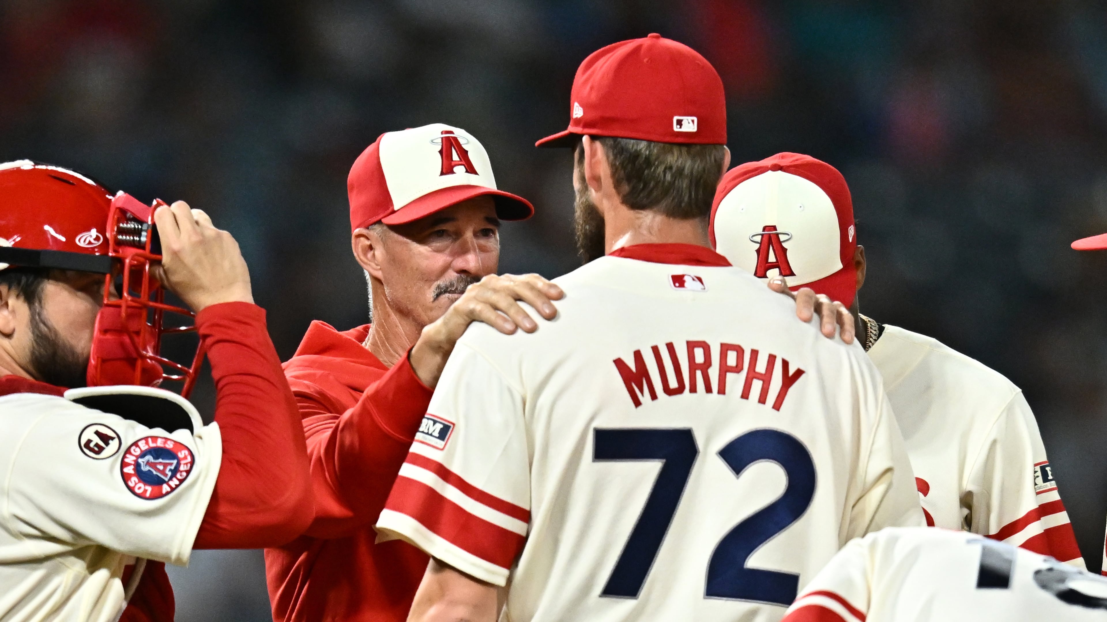 Los Angeles Angels pitcher Luke Murphy (72) speaks with pitching coach Mike Maddux, second from left, during the eighth inning of a baseball game against the Milwaukee Brewers, Friday, July 31, 2026, in Anaheim, Calif. (AP Photo/William Liang)