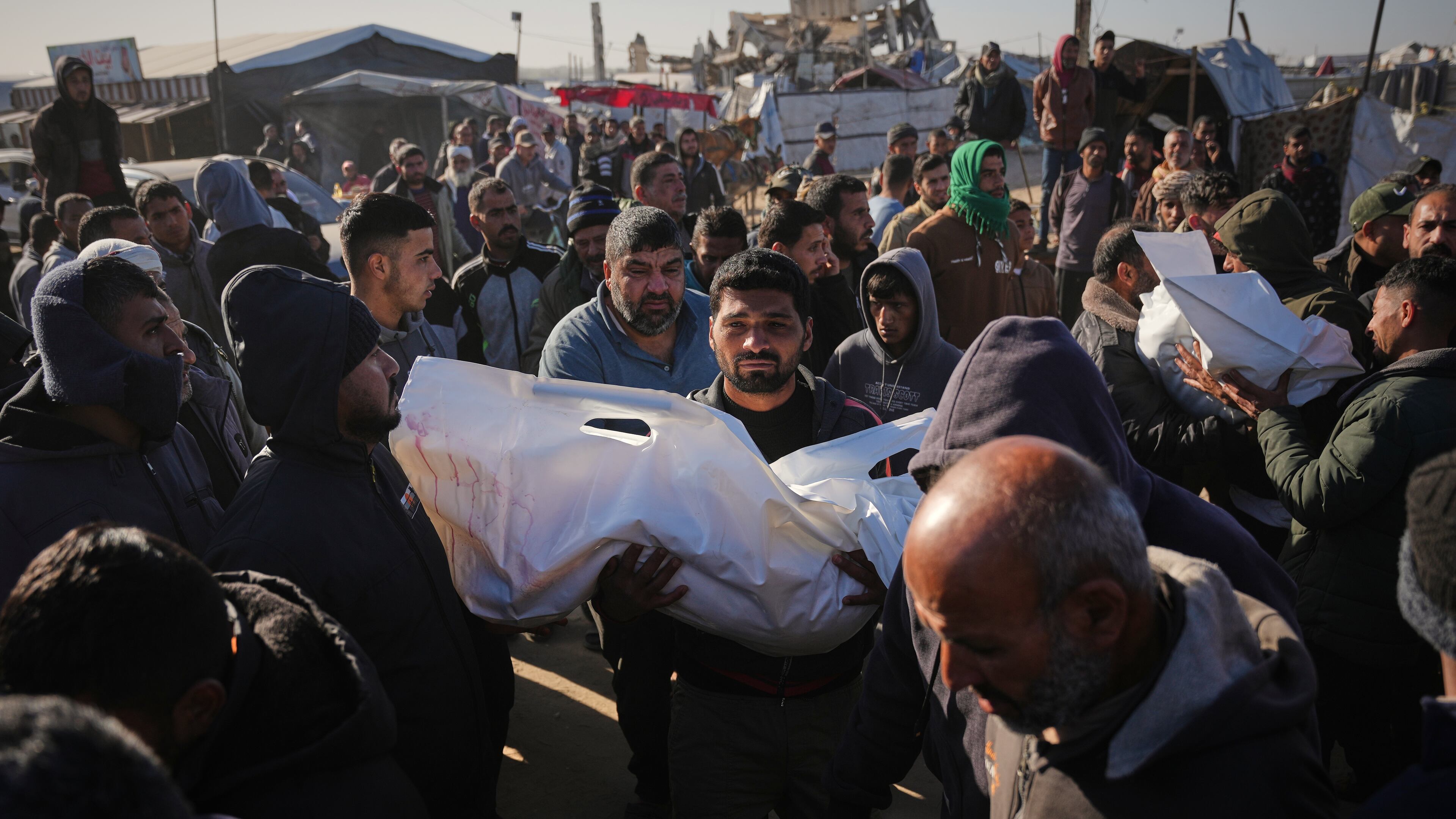 A Palestinian man carries the body of Sham Abu Hadaiyd, who was killed in an Israeli strike on a tent in Khan Younis, Gaza Strip, Saturday, Jan. 31, 2026. (AP Photo/Abdel Kareem Hana)