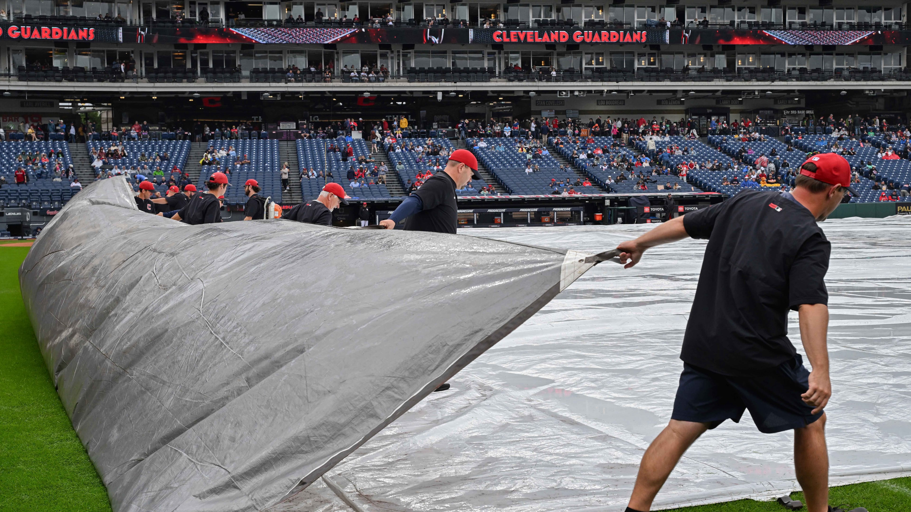 The Progressive Field grounds crew removes a tarp after a rain delay before a baseball game between the Athletics and the Cleveland Guardians, Sunday, Sept. 20, 2026, in Cleveland. (AP Photo/Phil Long)