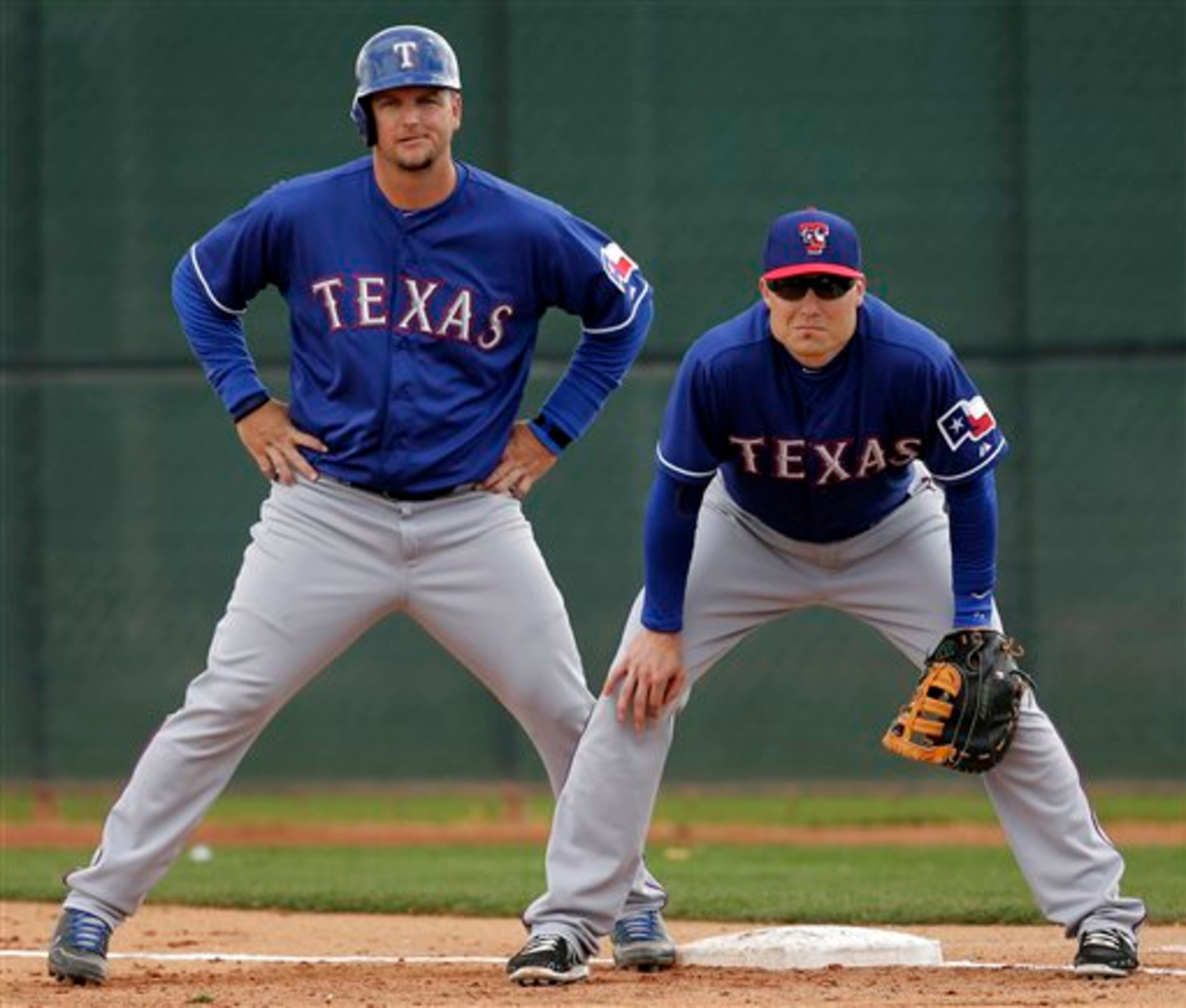 Texas Rangers' Jeff Baker, right, and A.J. Pierzynski watch from first base during an intrasquad game at baseball spring training, Wednesday, Feb. 20, 2013, in Surprise, Ariz. (AP Photo/Charlie Riedel)