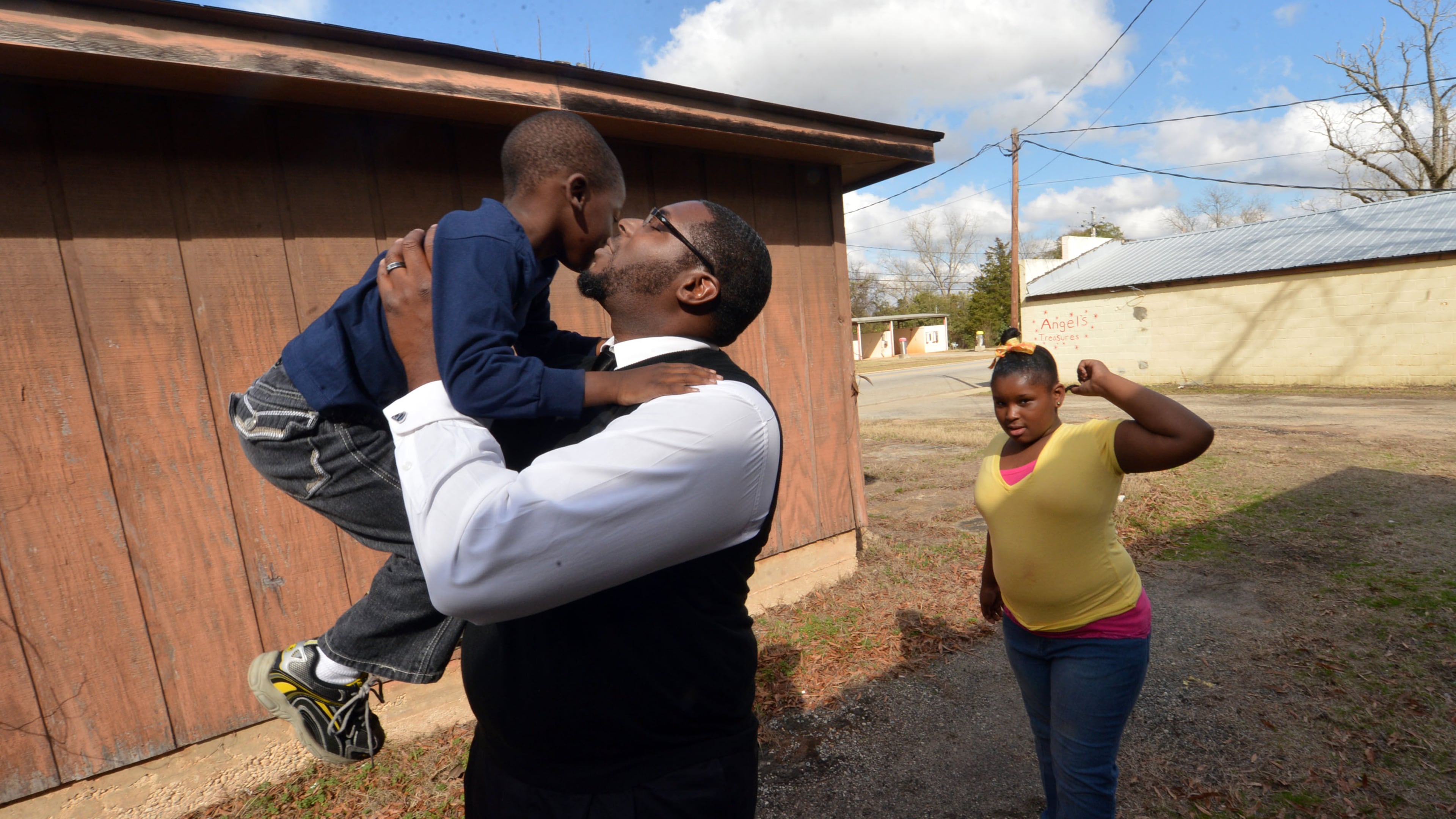 Lumpkin mayor Charles Gibson gives a kiss to his son, Genesis, 5, as his daughter Chaotic, 9, plays nearby.