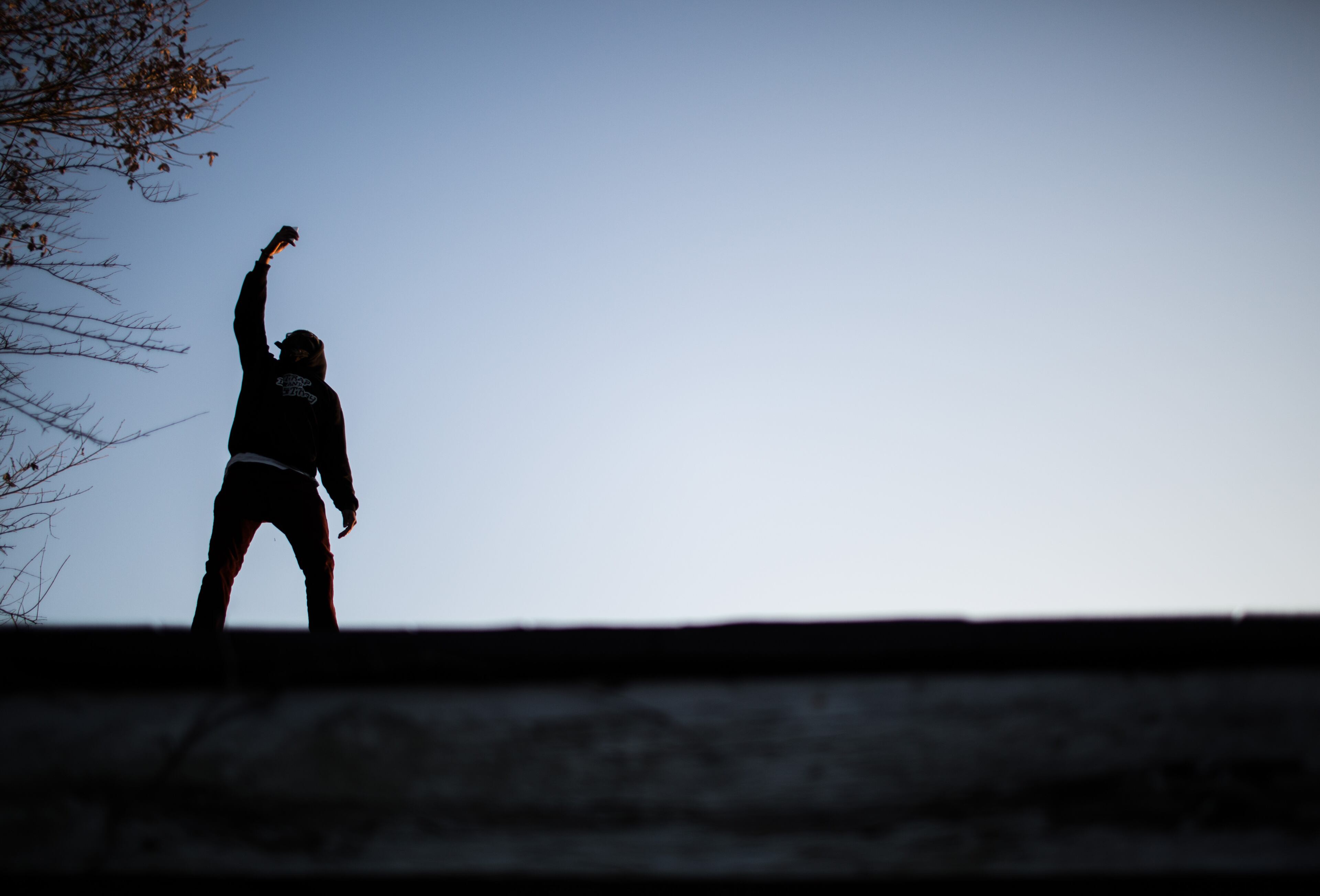 Silhouetted by the evening sky, a man takes a photo with his cellphone on top of an old abandoned motel during the Phoenix Festival held at Urban Sprout Farms, Saturday, Nov. 15, 2014 in Atlanta. The Atlanta arts community came together to present a day of music, literature and art to raise awareness for creative repurposing of land that once laid to waste. (SPECIAL/BRANDEN CAMP)