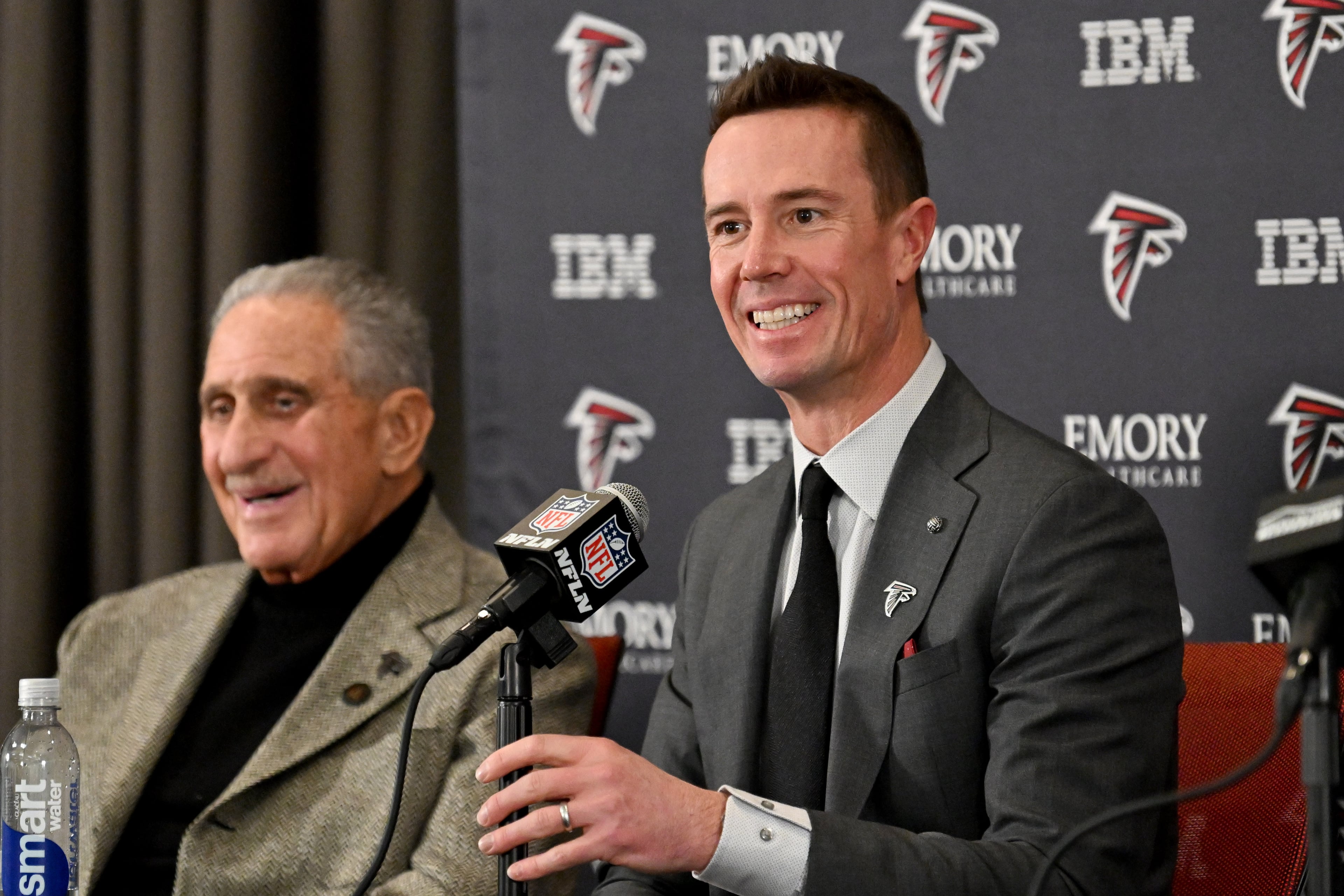 New Atlanta Falcons president of football Matt Ryan speaks as Falcons owner Arthur M. Blank (left) reacts during an introductory news conference Jan. 13, 2026, in Flowery Branch. It is now thought Ryan could be leaning toward James Liipfert as the team's new general manager. (Hyosub Shin/AJC)