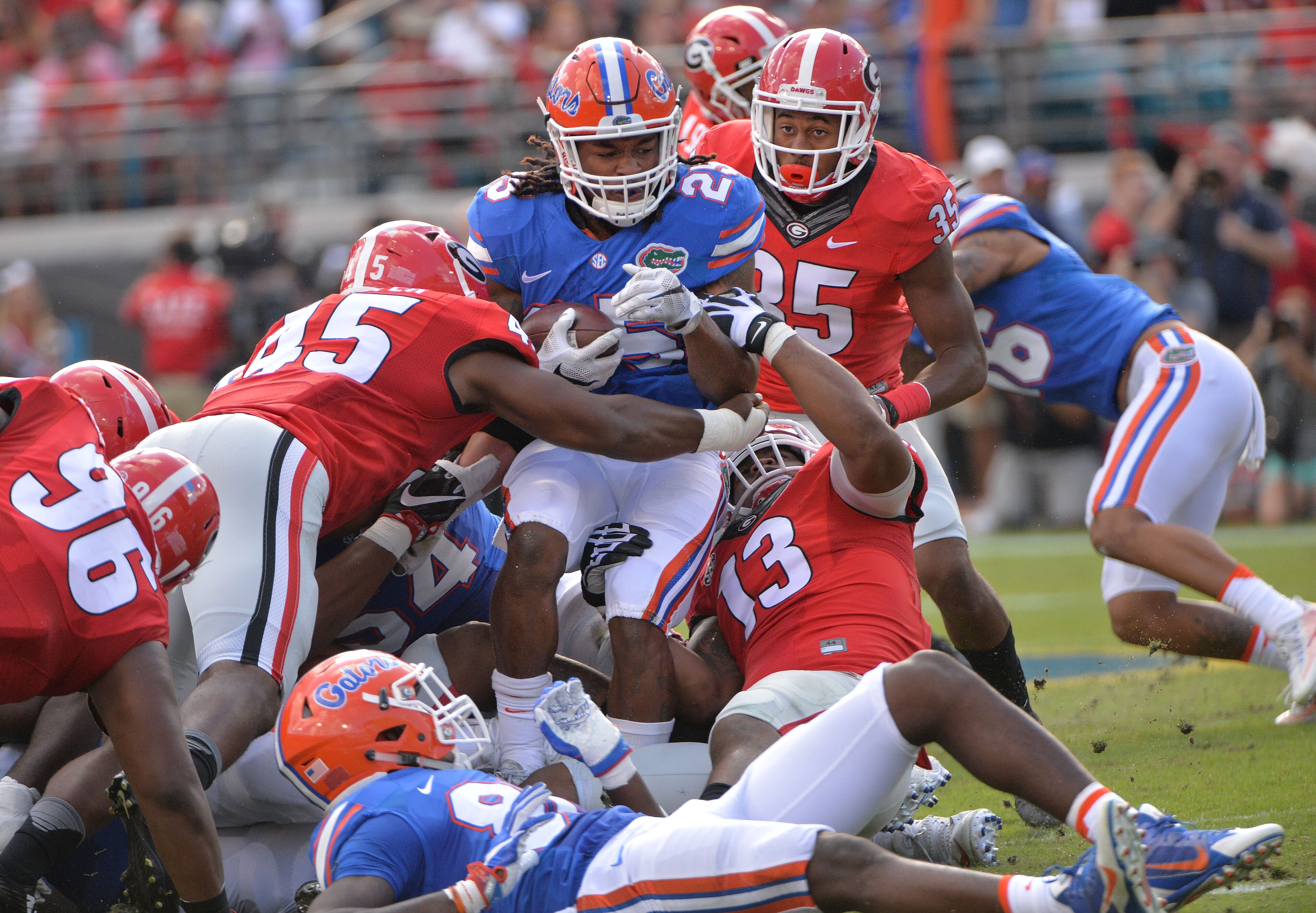 October 29, 2016 Jacksonville, Fla. - Florida running back Jordan Scarlett (25) is brought down by Georgia cornerback Aaron Davis (35) and Georgia defensive end Jonathan Ledbetter (13) in the first half at EverBank Field in Jacksonville, Florida on Saturday, October 29, 2016. HYOSUB SHIN / HSHIN@AJC.COM