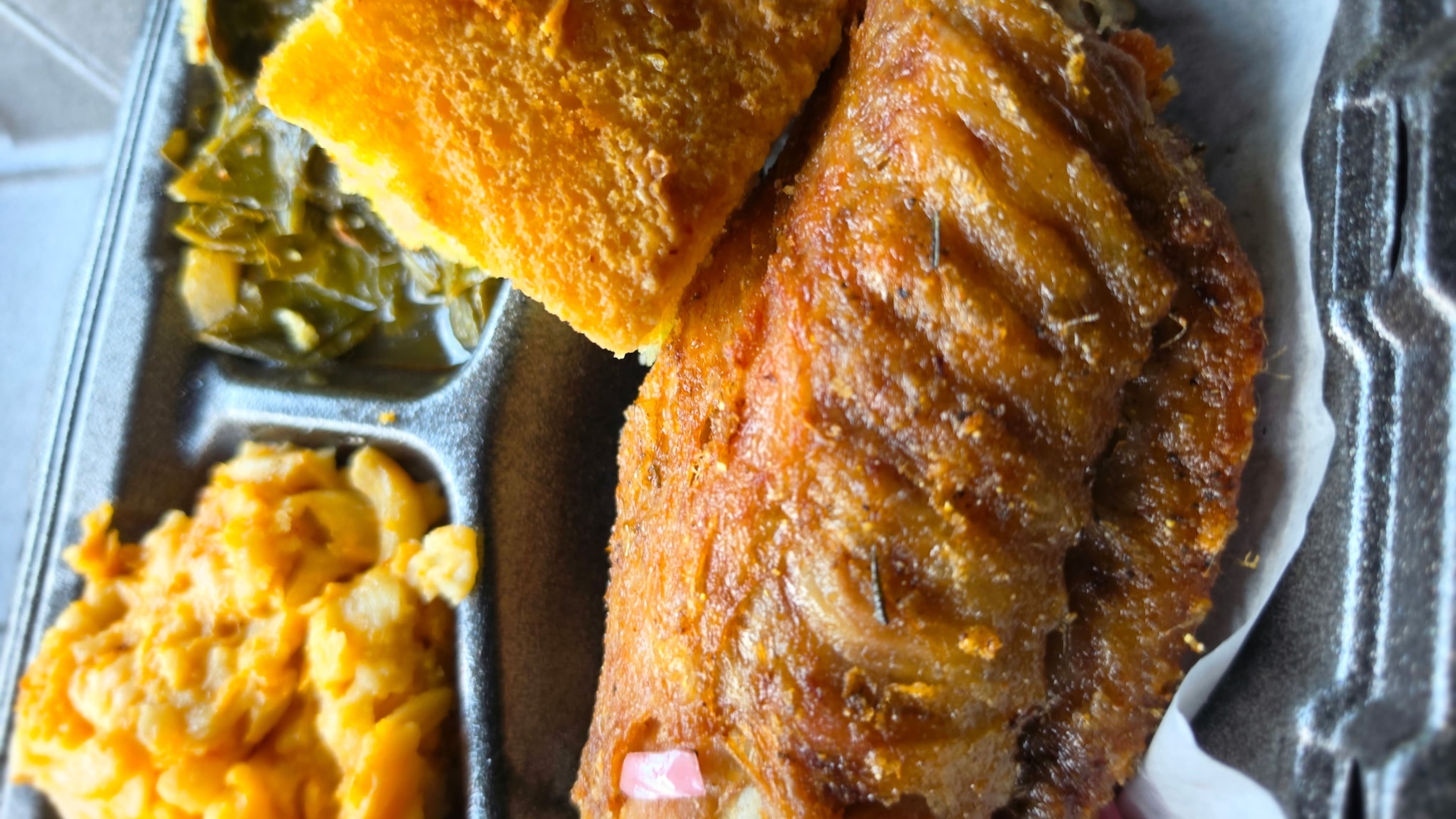 Soul Food & Culture's lemon pepper turkey wing, with sides of macaroni and cheese, collard greens and cornbread. (Justin Brown for the AJC)
