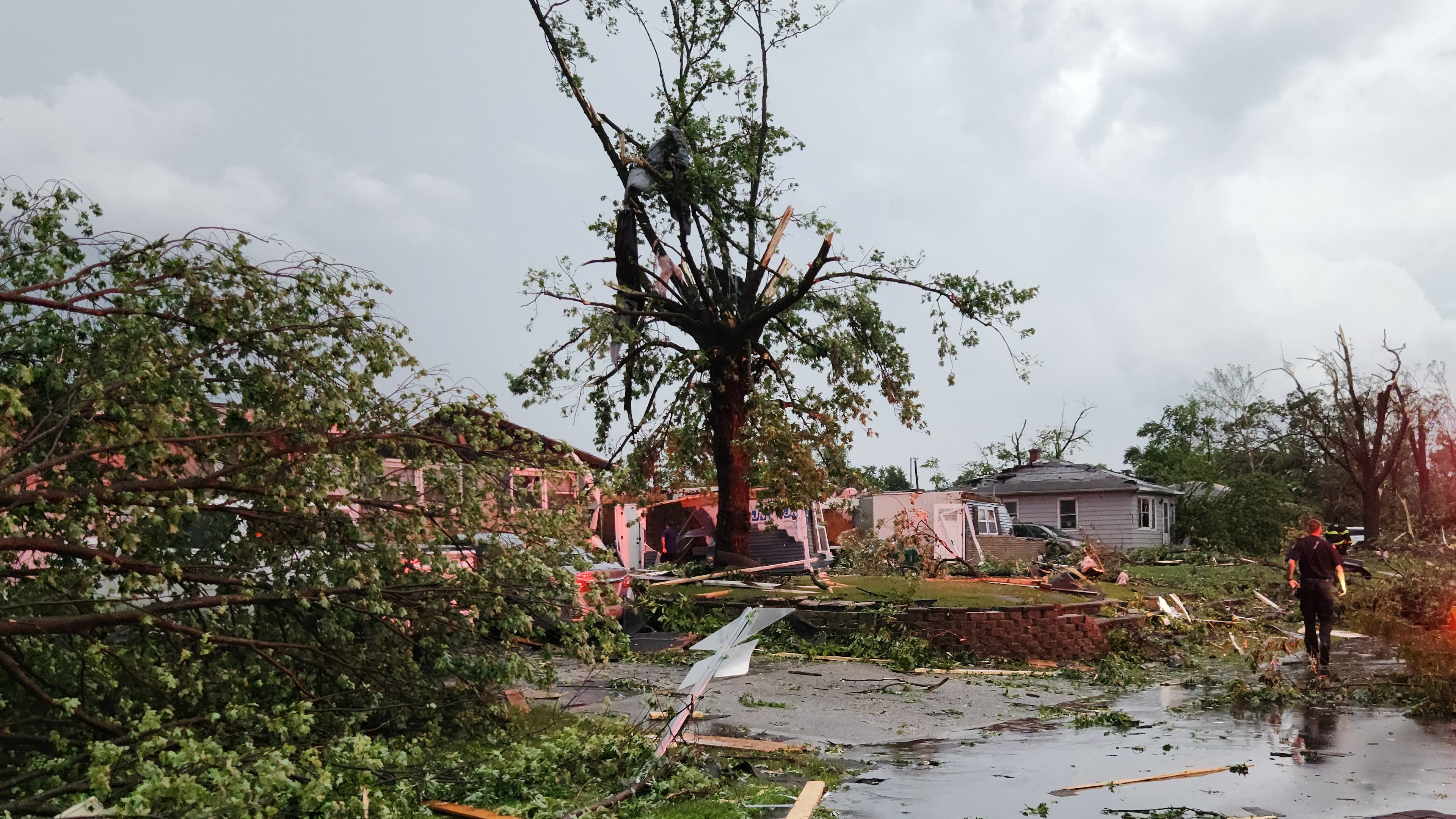 First responders walk through debris on Thursday, June 11, 2026 after a tornado passed through Merrillville, Ind. (Michael Sneiderwine via AP)