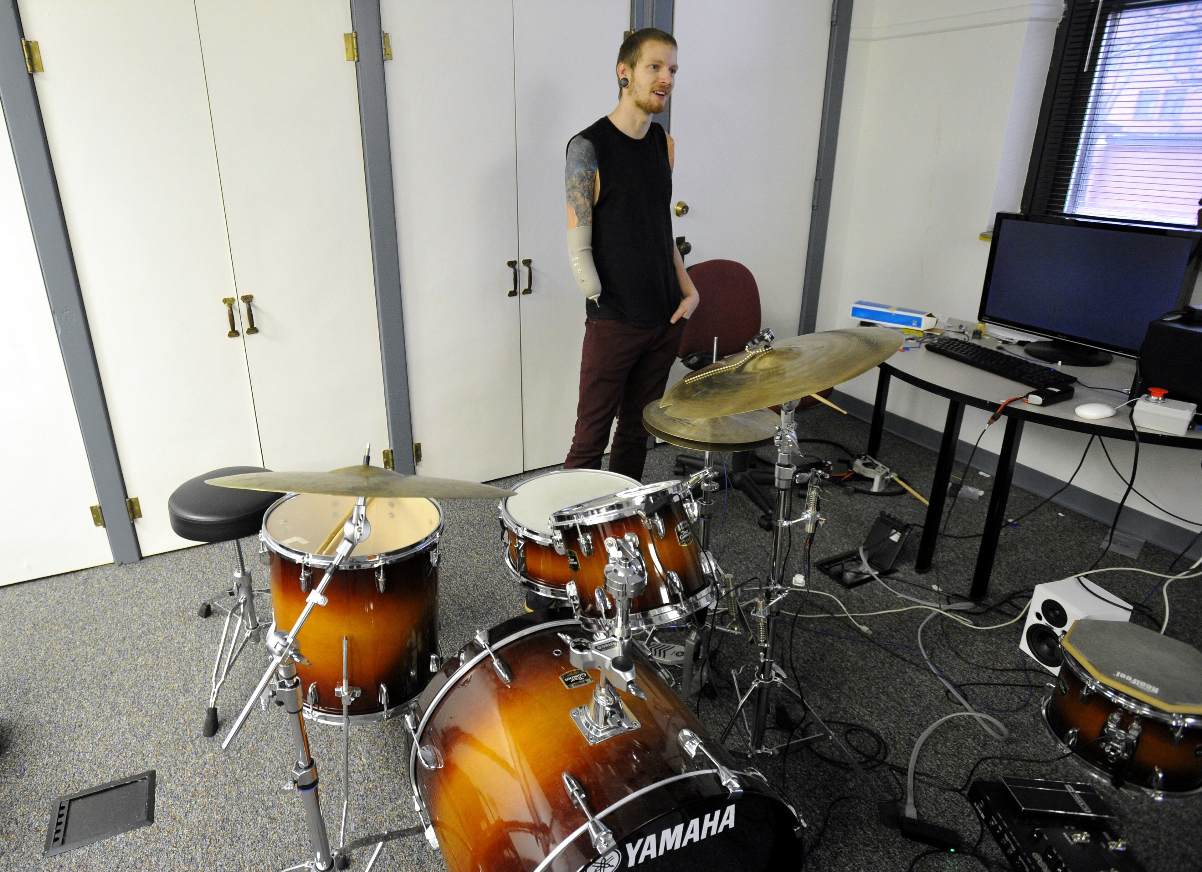 Rock, blues and jazz drummer Jason Barnes lost his right hand in an accident but a team of Georgia Tech robotics specialists devised a myo-electrically controlled robot arm to replace his missing drumming hand and they fine-tune the new wearable drumming device in the music lab Sunday, March 16, 2014, in Atlanta. The engineering team is preparing drummer Barnes for a concert this weekend at Kennesaw State University. David Tulis / AJC Special