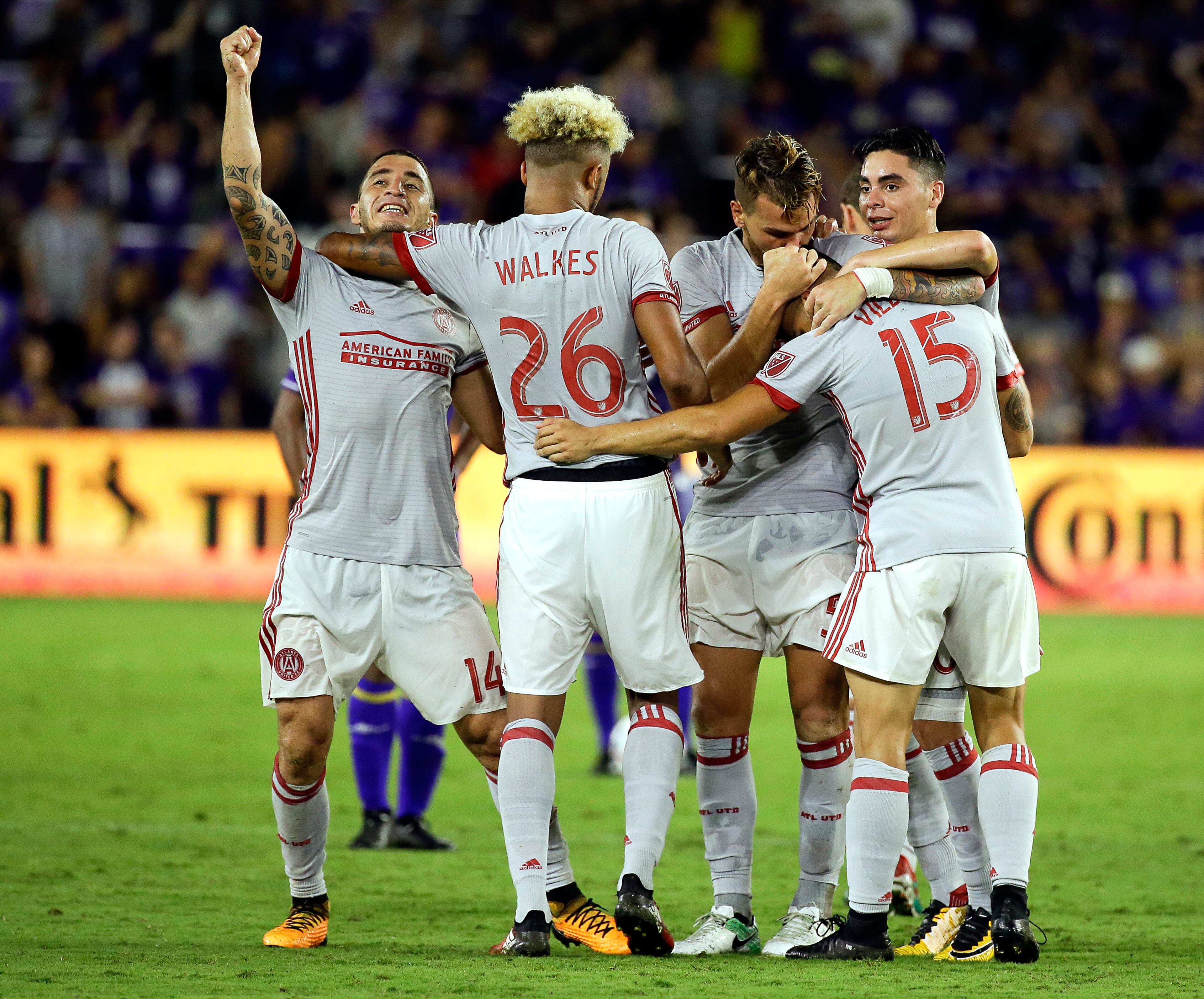 Atlanta United's Hector Villalba (15) is surrounded by teammates including Carlos Carmona (14) and Anton Walkes (26) after he scored against Orlando City during the second half of an MLS soccer match, Friday, July 21, 2017, in Orlando, Fla. Atlanta United won 1-0. (AP Photo/John Raoux)
