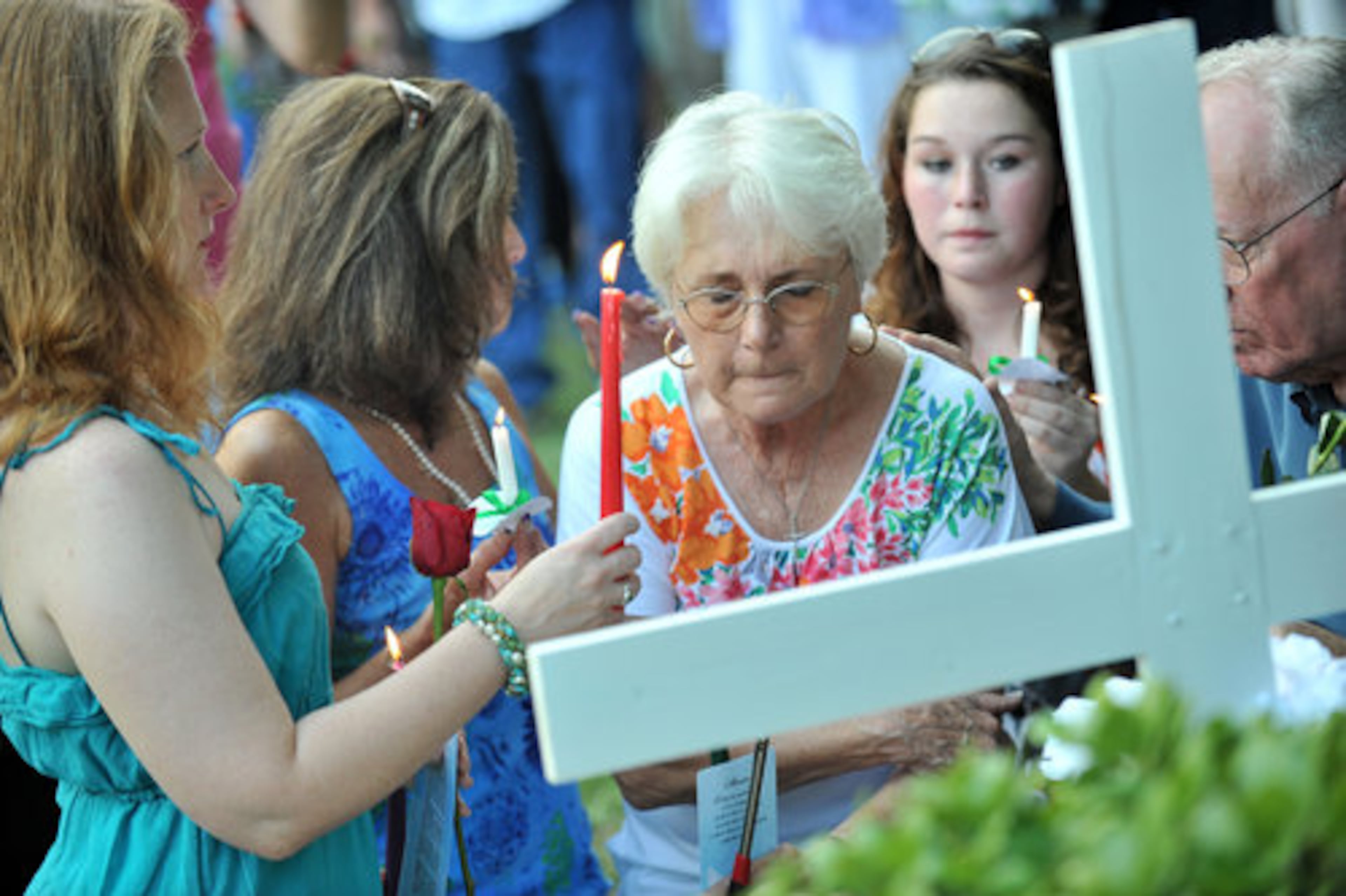 Family members of Nique Leili (from left) Amy Elk (sister), Kathy White (sister), Harriett Garrett (mother) and Doug Chatham (far right, father) gather at memorials during the candlelight vigil.