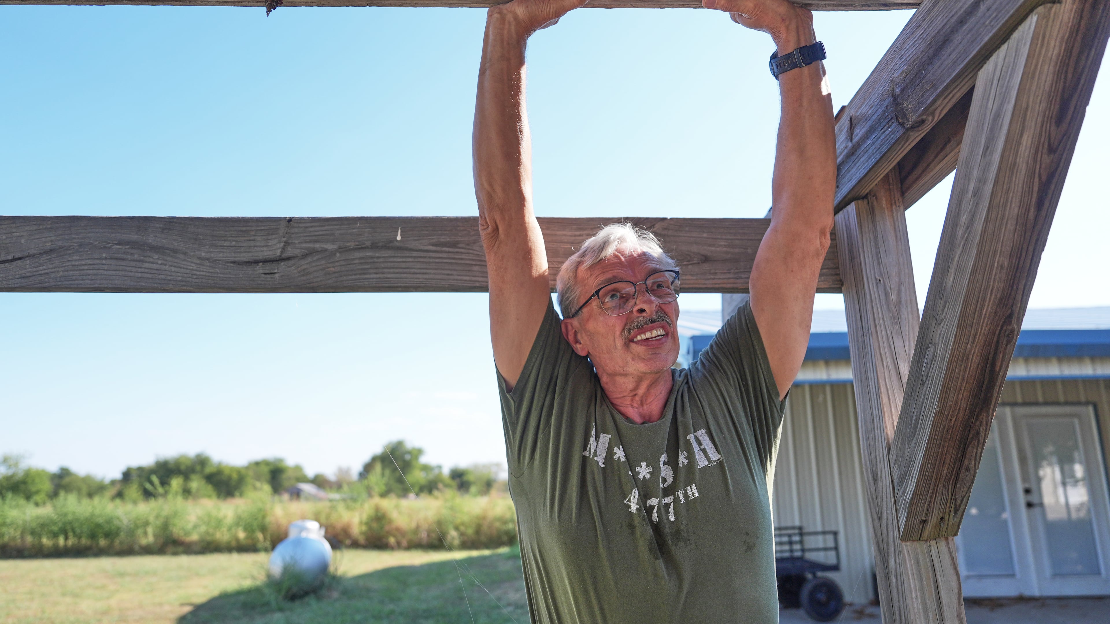 Ed Westrick, 59, adjusts a roof on a small building at his rural home near Commerce, Texas, Friday, Sept. 18, 2026. (AP Photo/LM Otero)