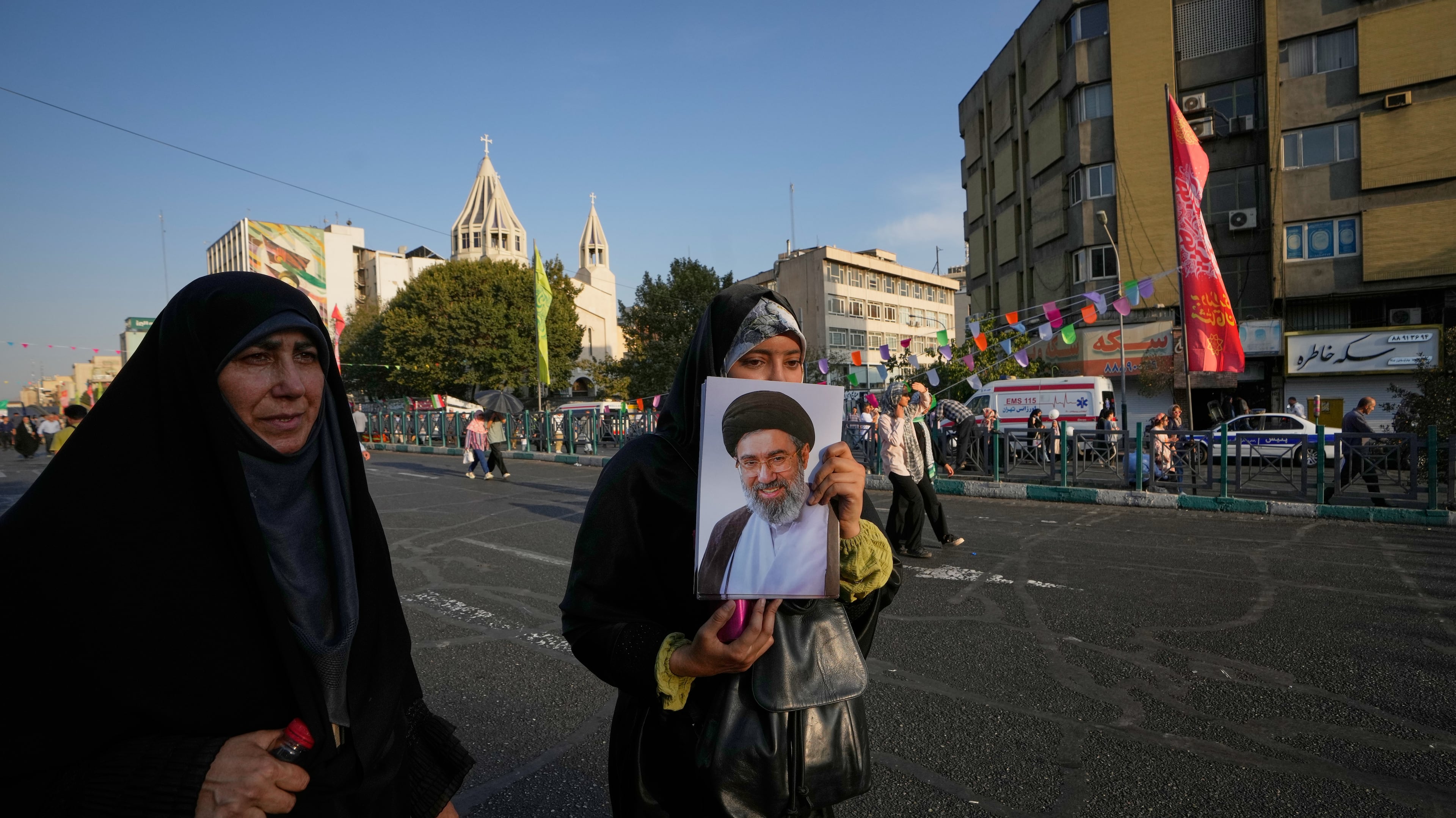 A government supporter holds a portrait of Iran's Supreme Leader Mojtaba Khamenei during a street celebration marking Prophet Muhammad's birthday, with St. Sarkis Armenian Cathedral in the background, in Tehran, Iran, Sunday, Aug. 30, 2026. (AP Photo/Vahid Salemi)