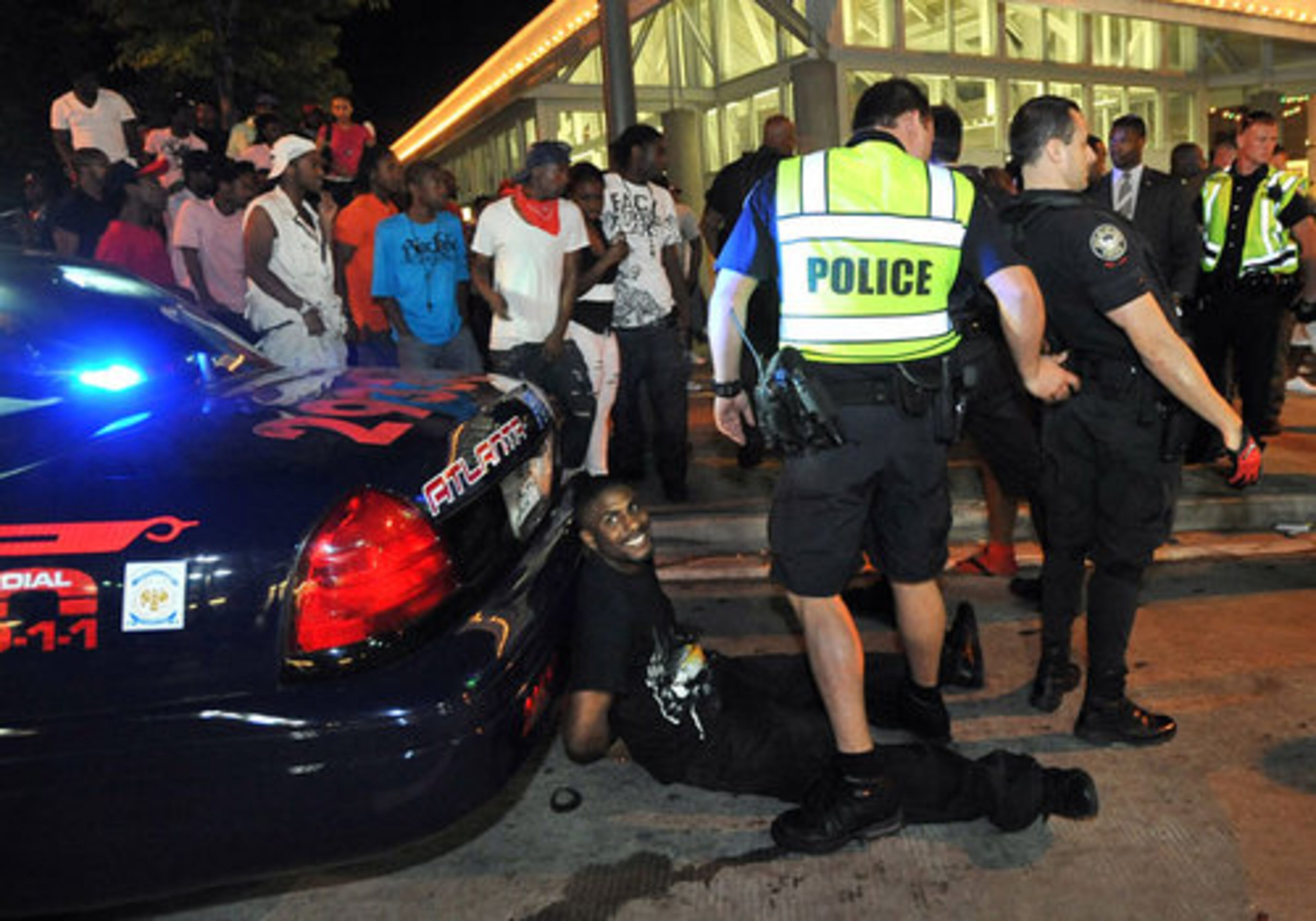 A man sits on the ground in handcuffs Saturday night during Freaknik event at the Underground Atlanta.