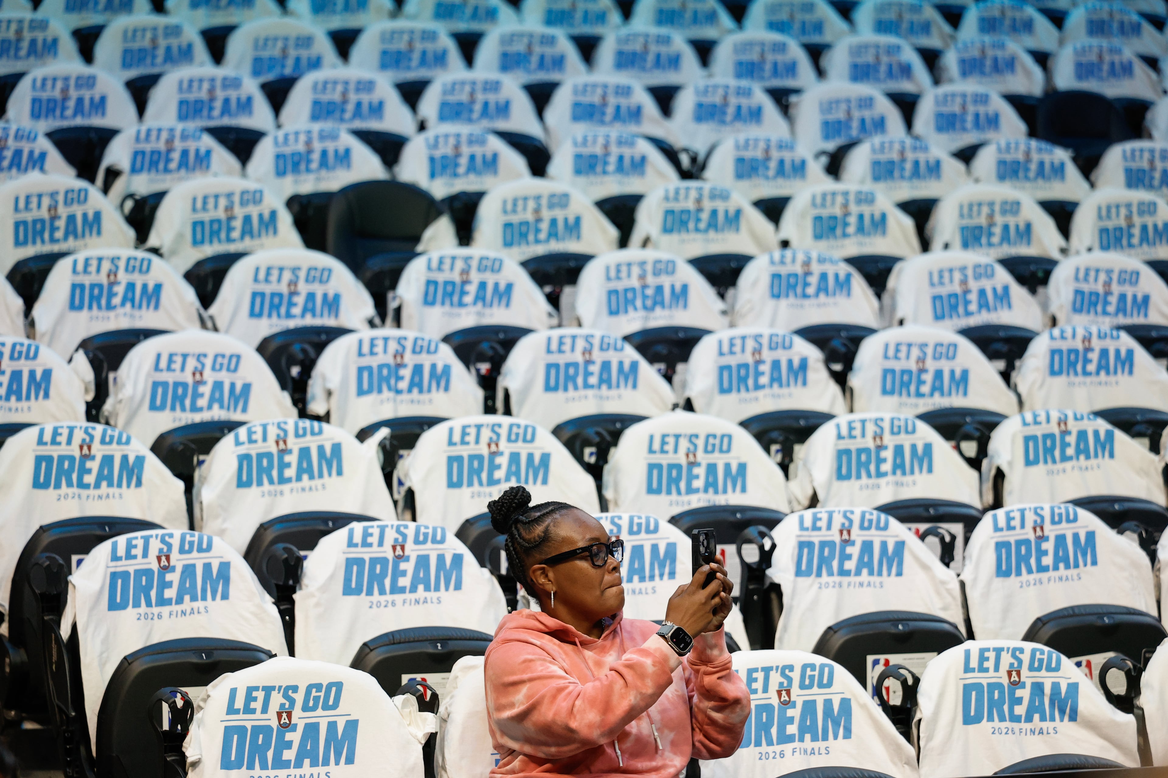 A woman watches teams warm up before game 4 of the WNBA Finals between the Atlanta Dream and the Golden State Valkyries, Saturday, Oct. 24, 2026, in Atlanta. (Erik S. Lesser for the AJC)