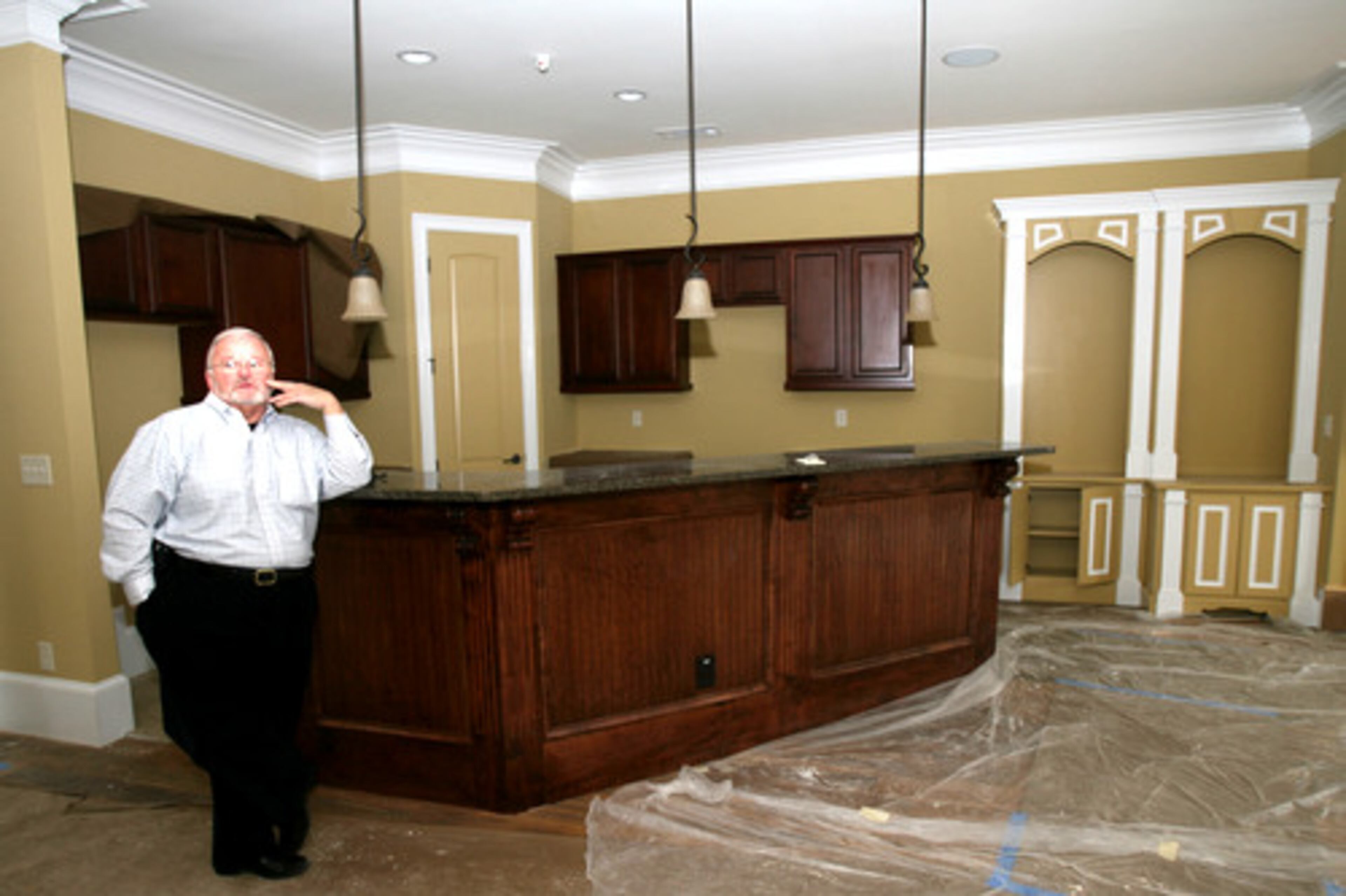 Bill O'Brien of Main Street Partner Group shows the features of the interior of a sales model in Asbury Park in Hapeville, Ga. on March 18, 2008. Teak floors, crown molding, bookshelves and custom paint are a part of the model home's design.
