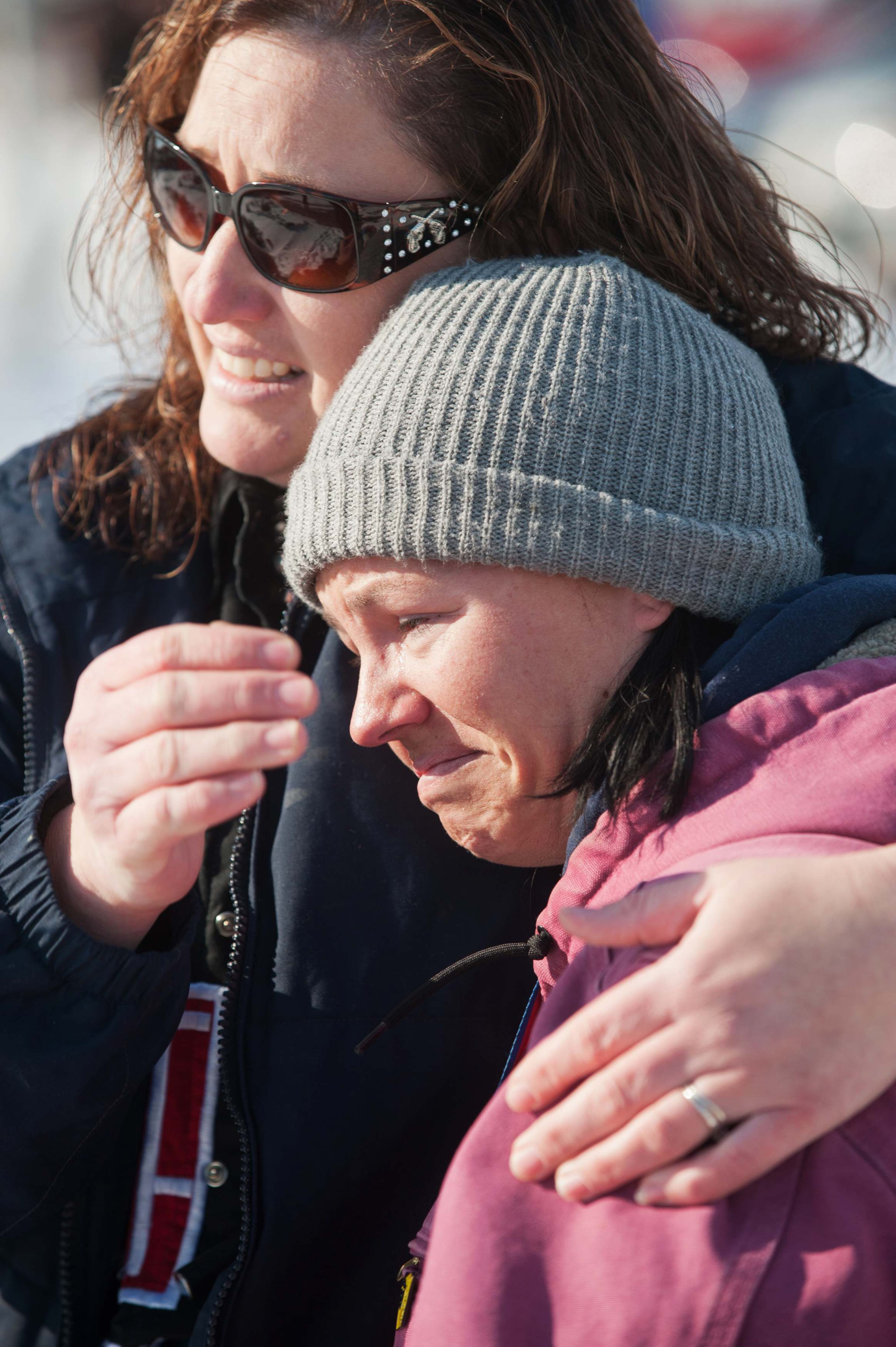 Connie Gottschalk (L), a close family friend and Linn Campbell comfort each other as rescue personnel unload a family at Pershing General Hospital who were were found safe in a remote mountain range northeast of Reno, in Lovelock, Nevada, December 10, 2013. A Nevada couple and four young children reported missing on Sunday were found safe by rescue workers on Tuesday huddled in a canyon, a dispatch supervisor for the Pershing County Sheriff's Office said. REUTERS/James Glover