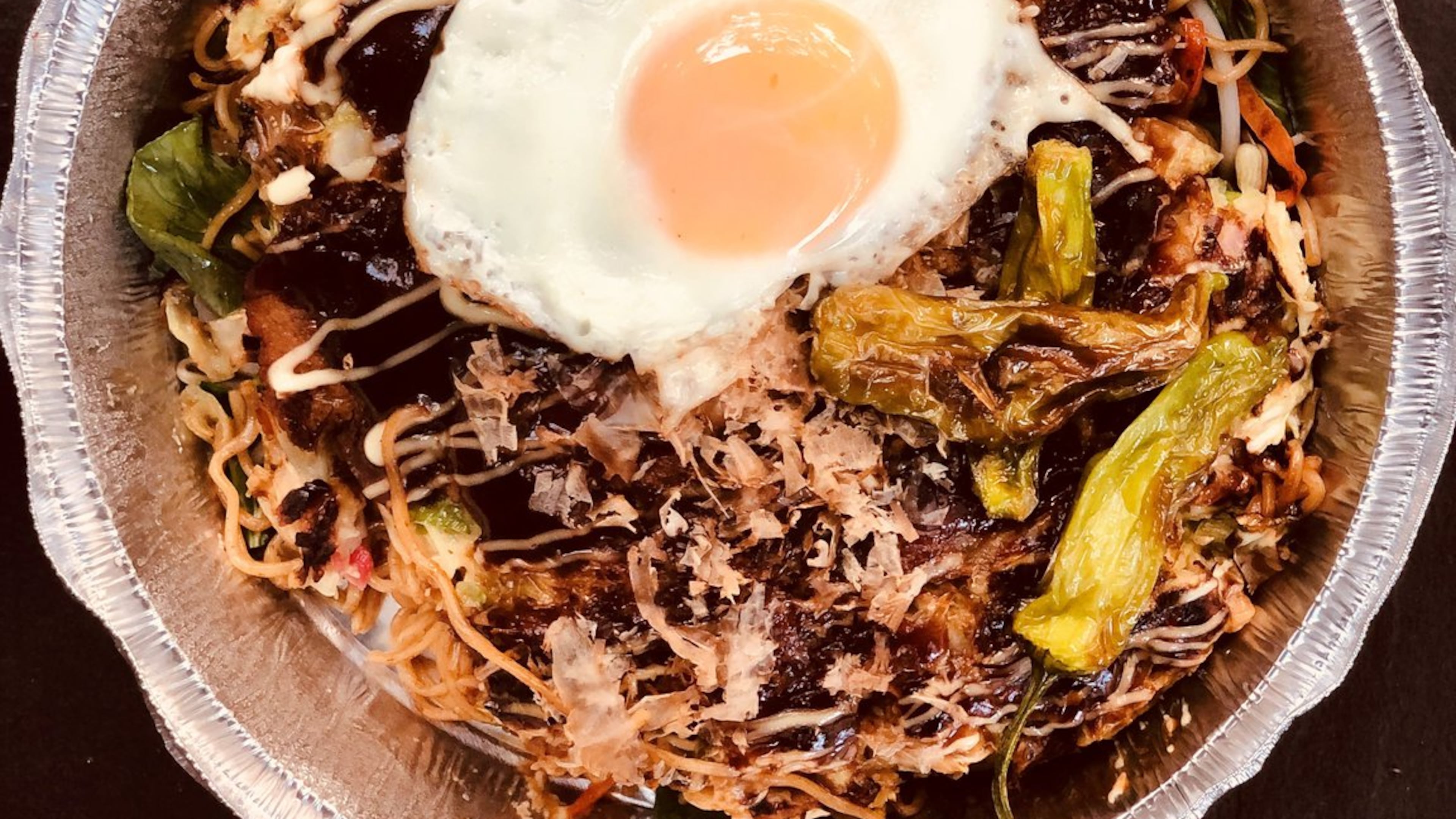 OK Yaki’s large okonomiyaki-yakisoba combo is seen here, with pork belly and fried egg added. The noodles (with added veggies) are under the pancake. CONTRIBUTED BY WENDELL BROCK