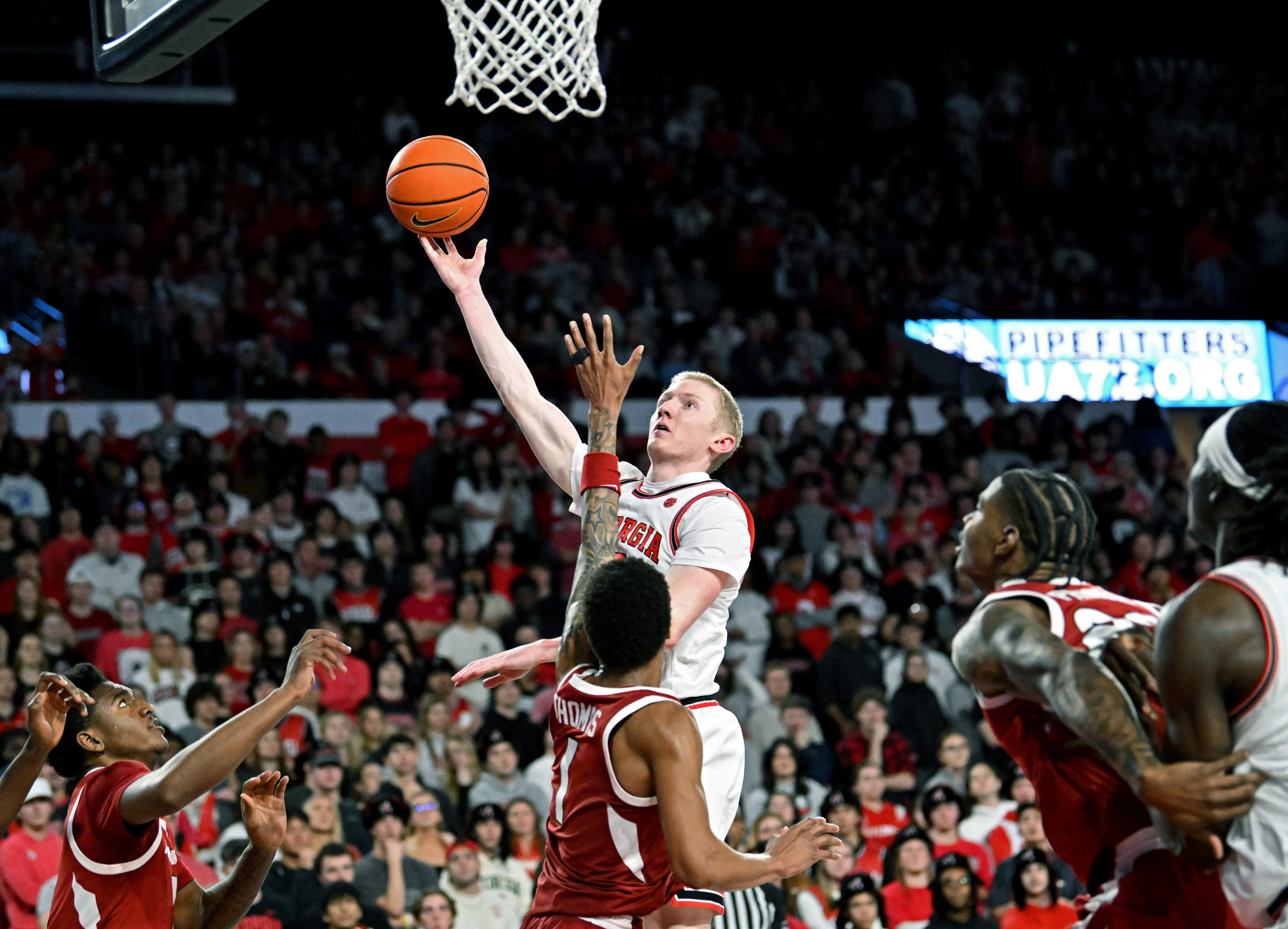 Georgia guard Blue Cain shoots over Arkansas guard Meleek Thomas during the second half in an NCAA college basketball game at Stegeman Coliseum, Saturday, Jan. 17, 2026, in Athens. Georgia won 90-76 over Arkansas. (Hyosub Shin/AJC)