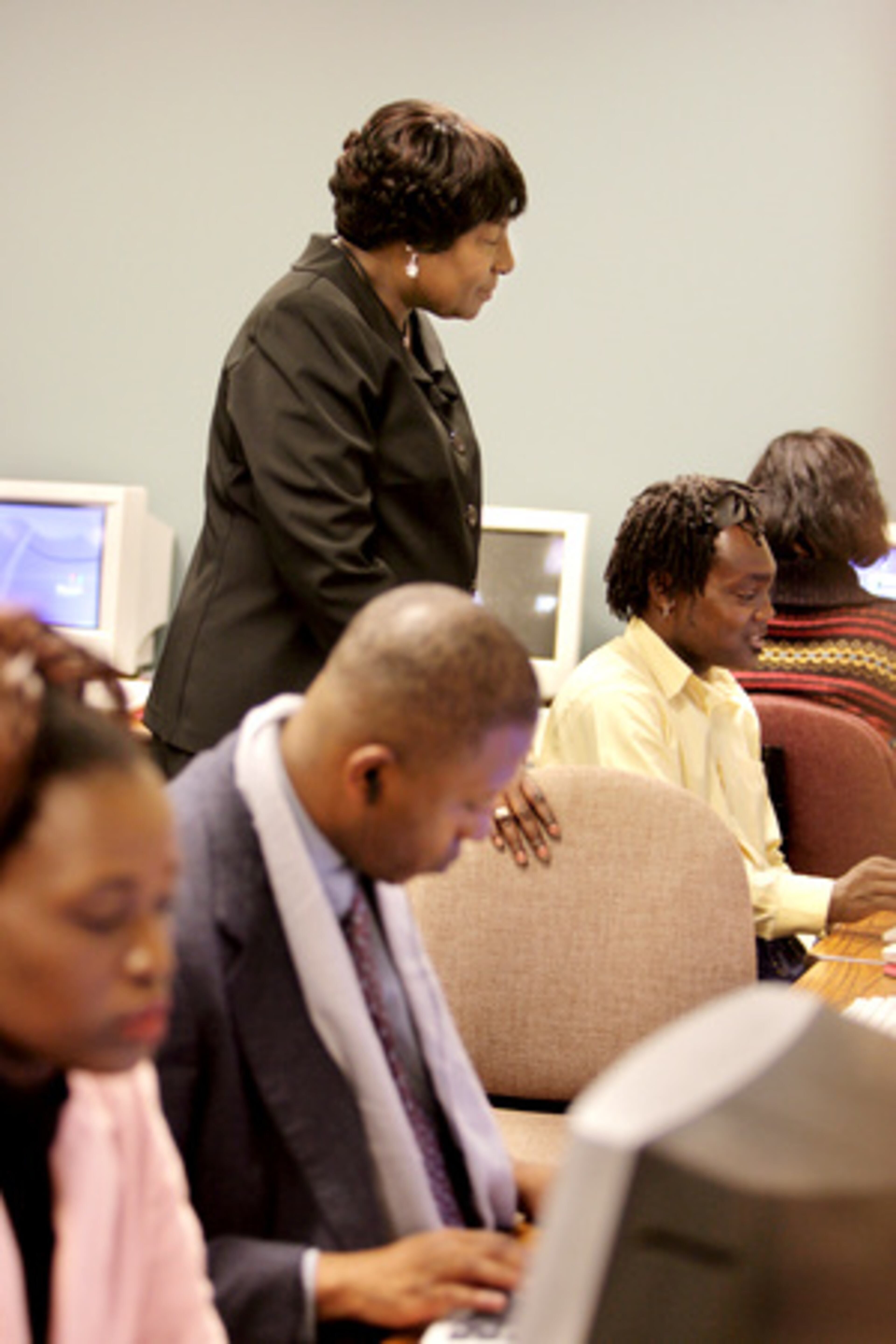 Rosa Gay showing her students some pointers in a banking and financial services class at the Atlanta Urban League. Gail Aska is on left, Jeffery Brown is in middle and James Blanks is closest to her (in yellow).