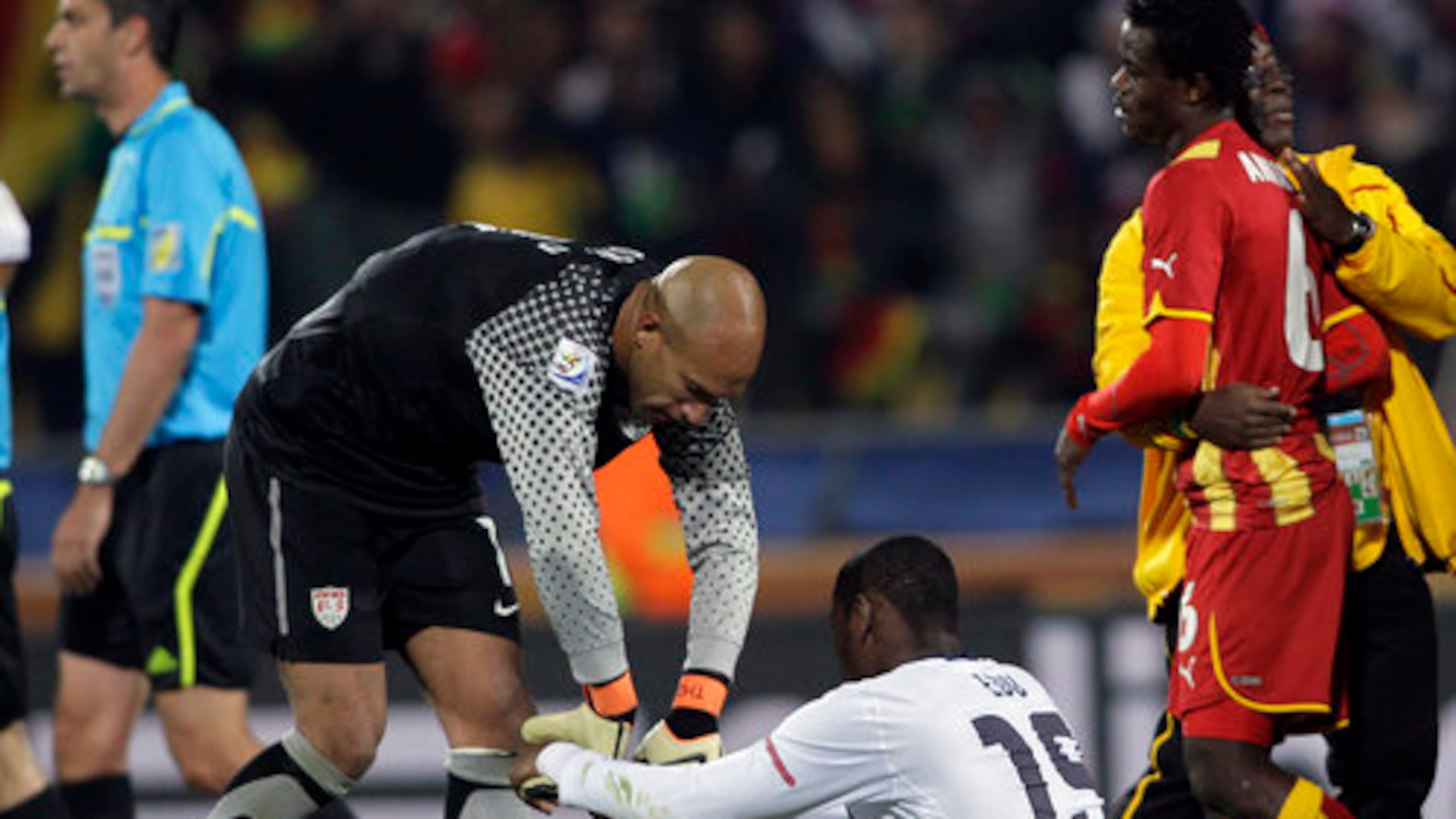 United States goalkeeper Tim Howard, left, helps United States' Maurice Edu, bottom, get up at the end of the World Cup round of 16 soccer match between the United States and Ghana at Royal Bafokeng Stadium in Rustenburg, South Africa, Saturday, June 26, 2010. Ghana won 2-1, advancing to the World Cup quarterfinals.