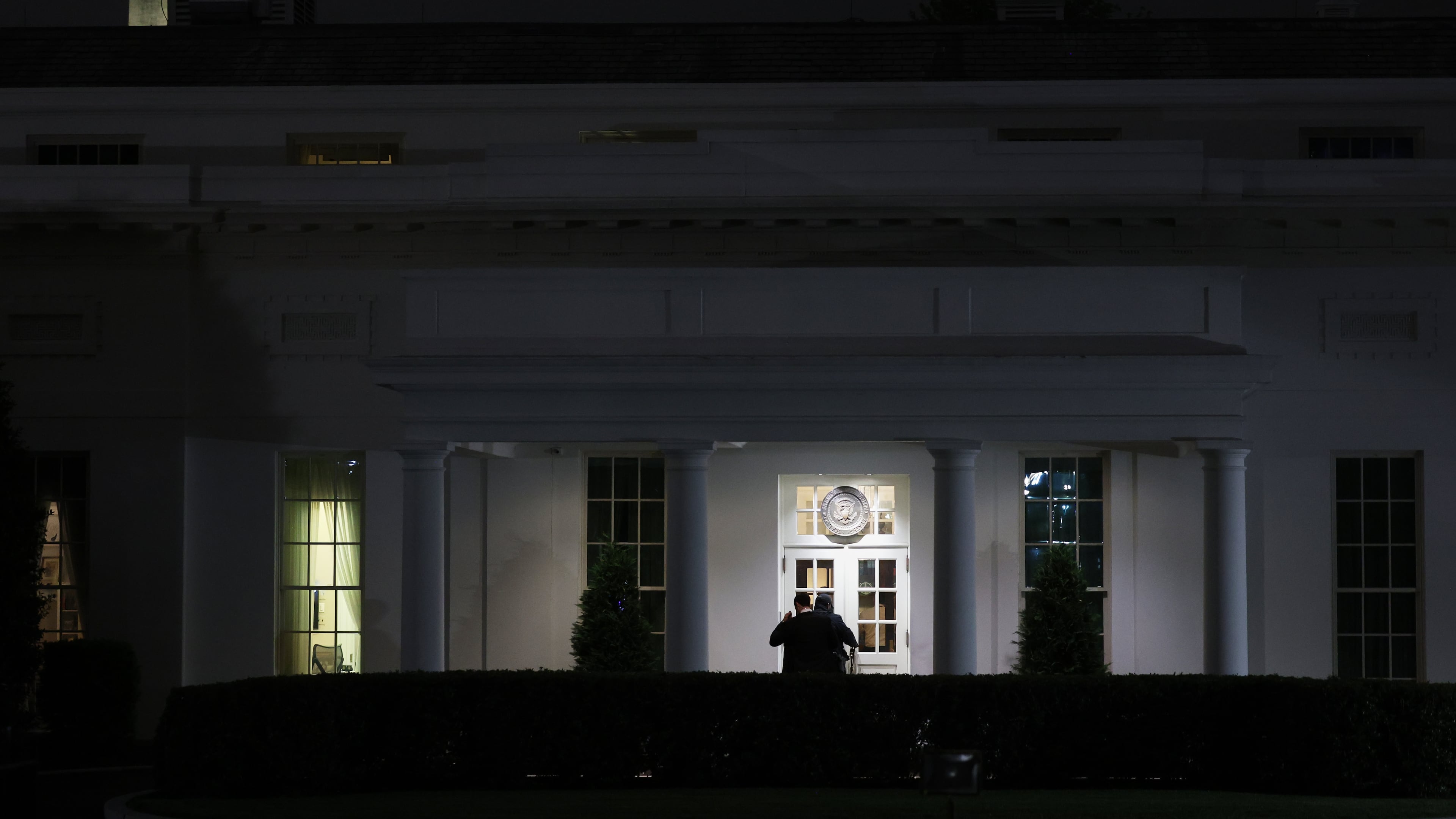 People are seen outside the West Wing driveway entrance of the White House, Saturday, April 25, 2026, in Washington. (AP Photo/Tom Brenner)