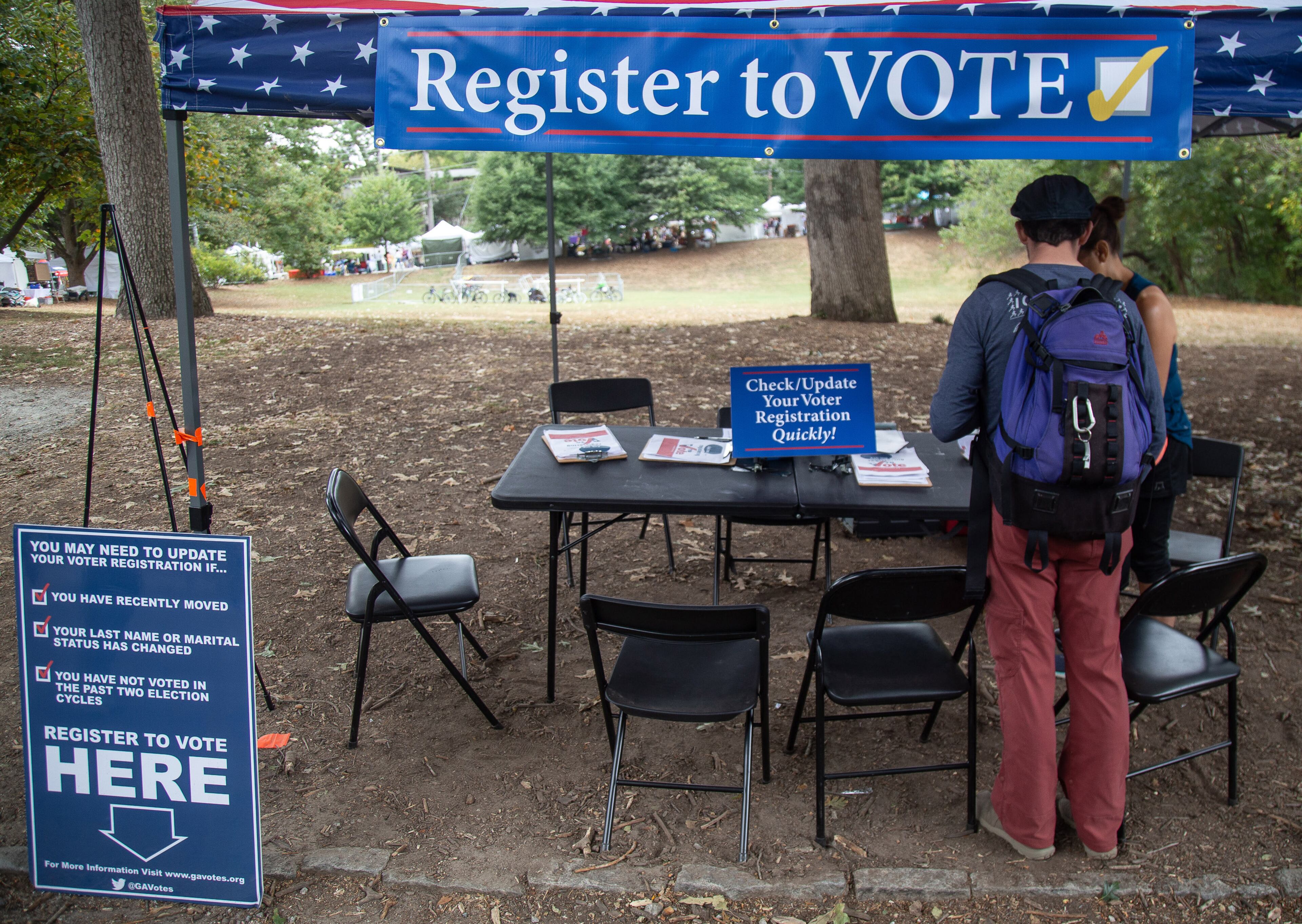 Greg Sawicki checks to make sure his voter registration is in order during the Candler Park Fall Fest 2019 in Atlanta on Sunday, October 6, 2019. STEVE SCHAEFER / SPECIAL TO THE AJC