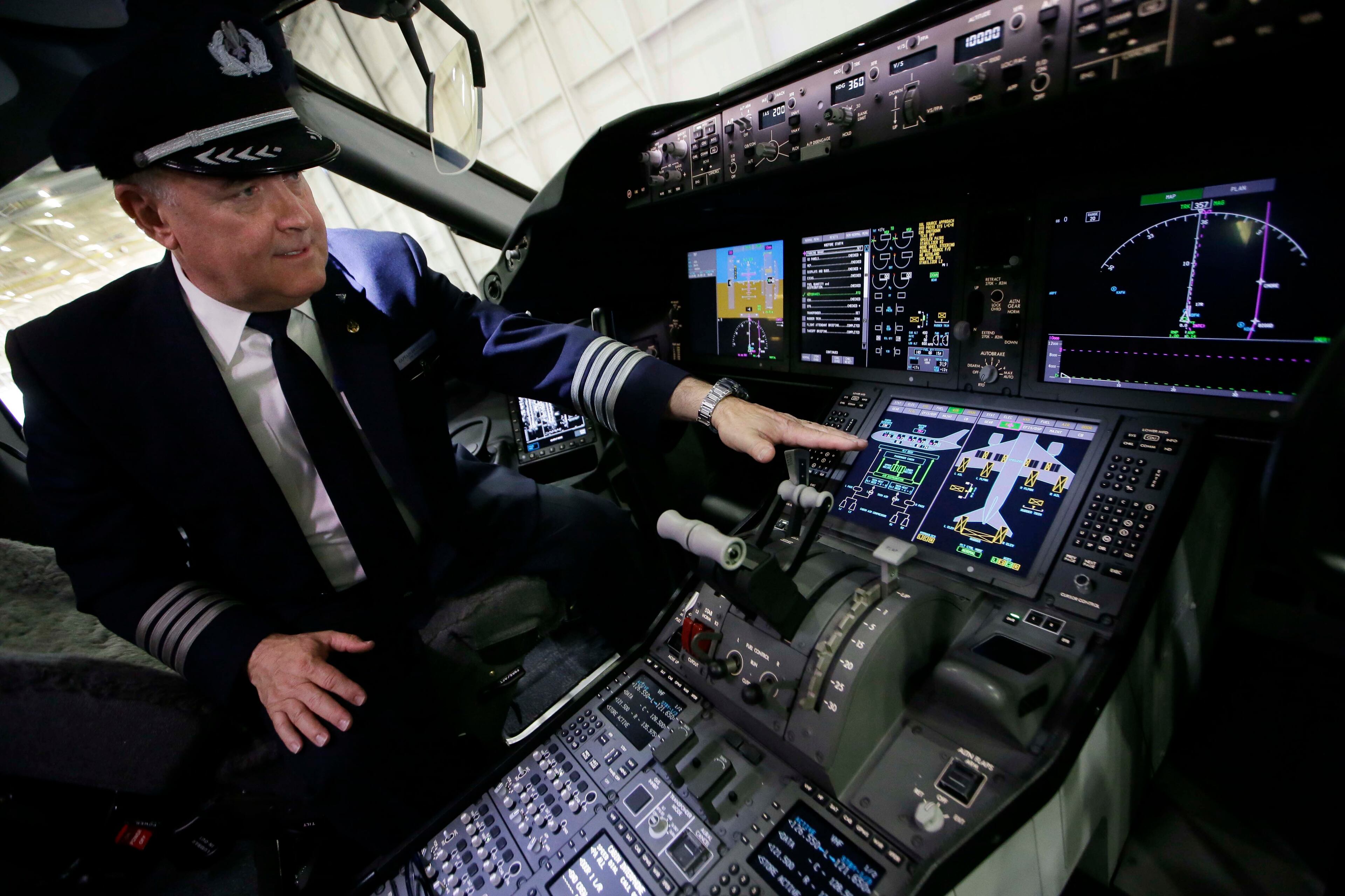 Captain Bruce Johnson explains the cockpit instruments of American Airlines' first Boeing 787 Dreamliner at the airline's maintenance hangar at Dallas-Fort Worth International Airport, Wednesday, April 29, 2015, in Grapevine, Texas. American Airlines unveiled the new passenger jet to employees and media before it goes into service May 7. (AP Photo/LM Otero)