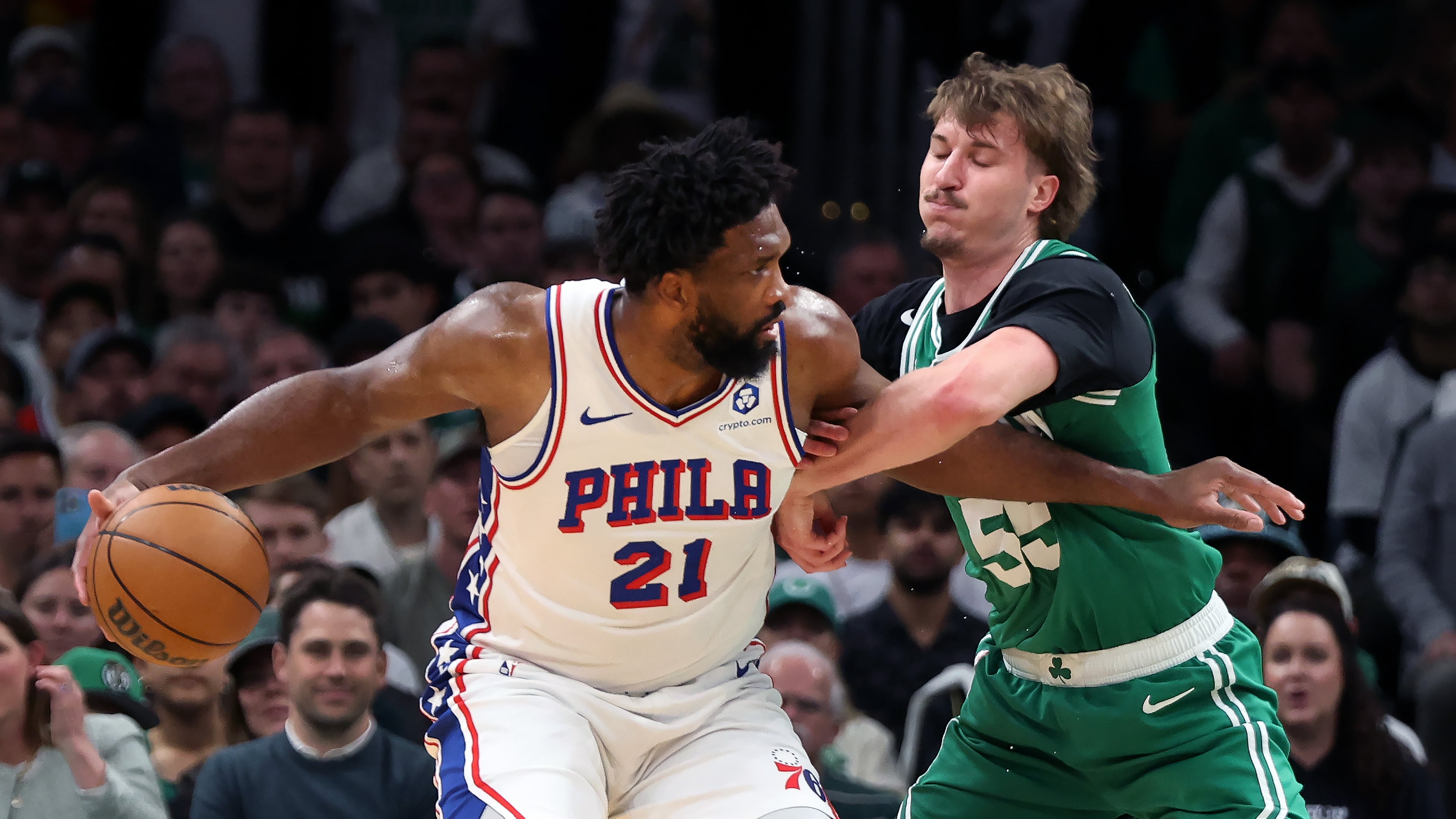 Boston Celtics' Jayson Baylor Scheierman (right) defends agianst Philadelphia 76ers' Joel Embiid (left) during the first half of Game 7 in a first-round NBA basketball playoffs series, Saturday, May 2, 2026 in Boston. (AP Photo/Jim Davis)
