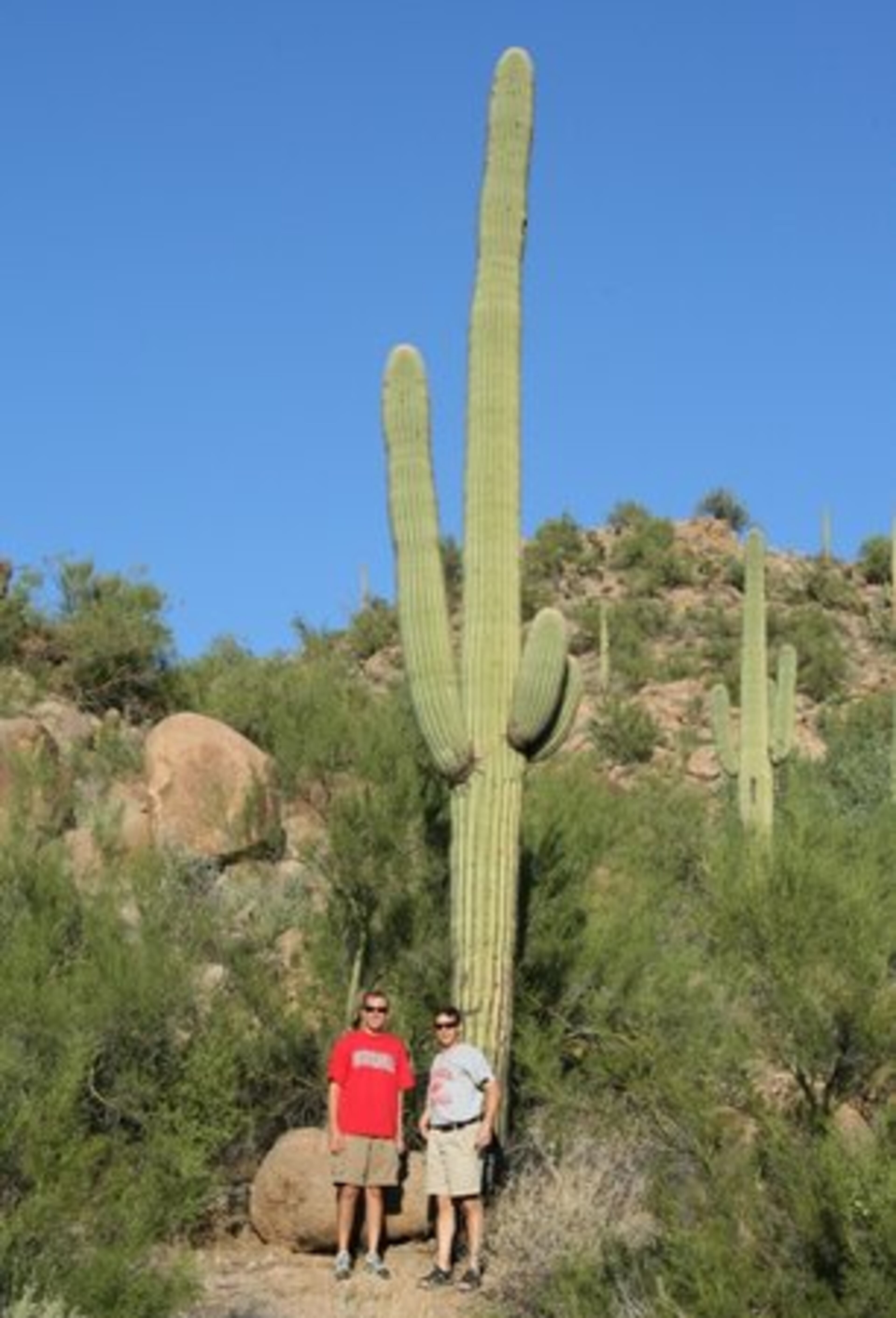 Brian Carr and Raul Trujillo in front of a Saguaro cactus in the Arizona desert.
