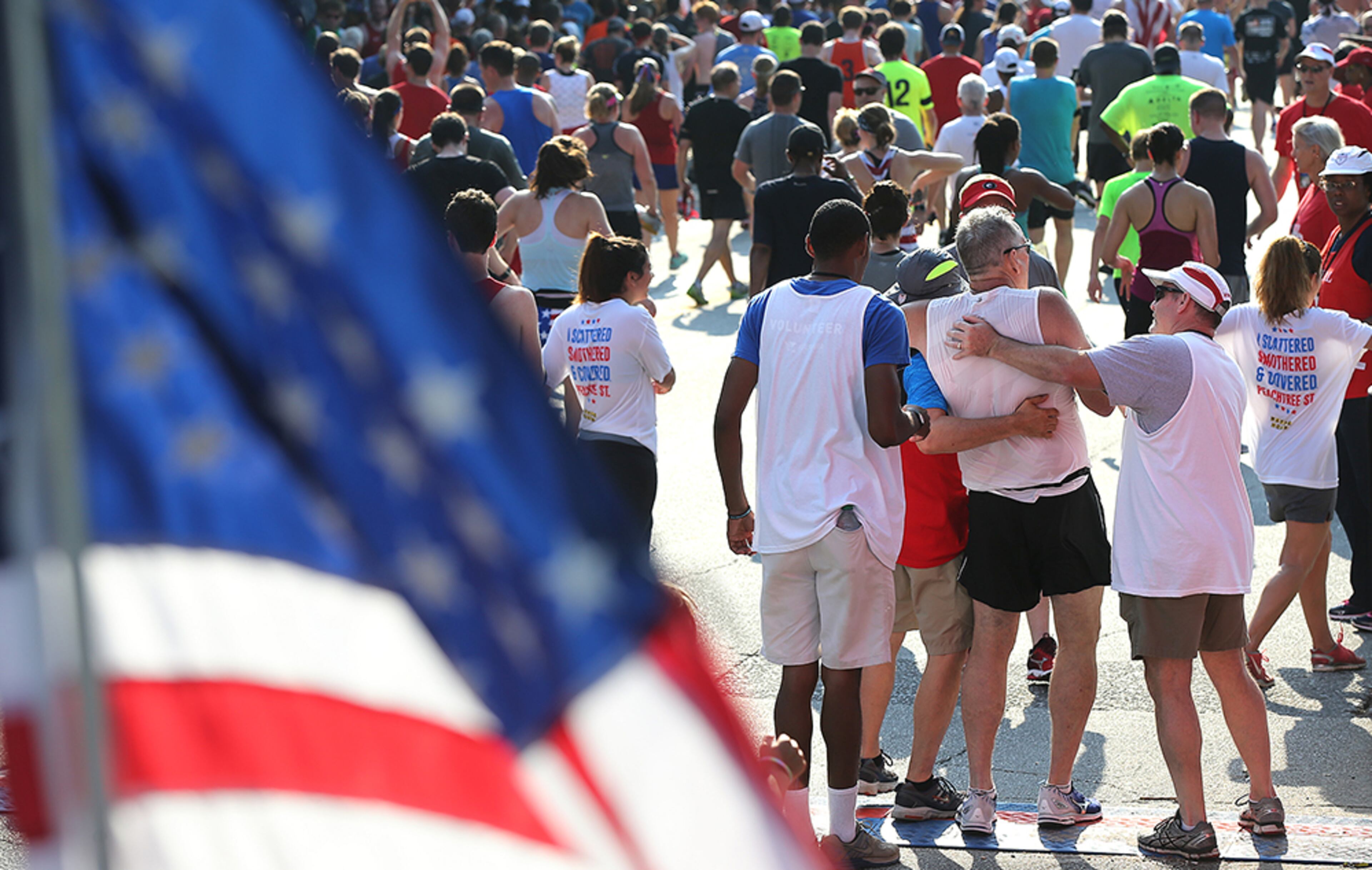 Medical personel help a runner cross the finish line in the 47th running of the AJC Peachtree Road Race at Piedmont Park on Monday, July 4, 2016, in Atlanta.