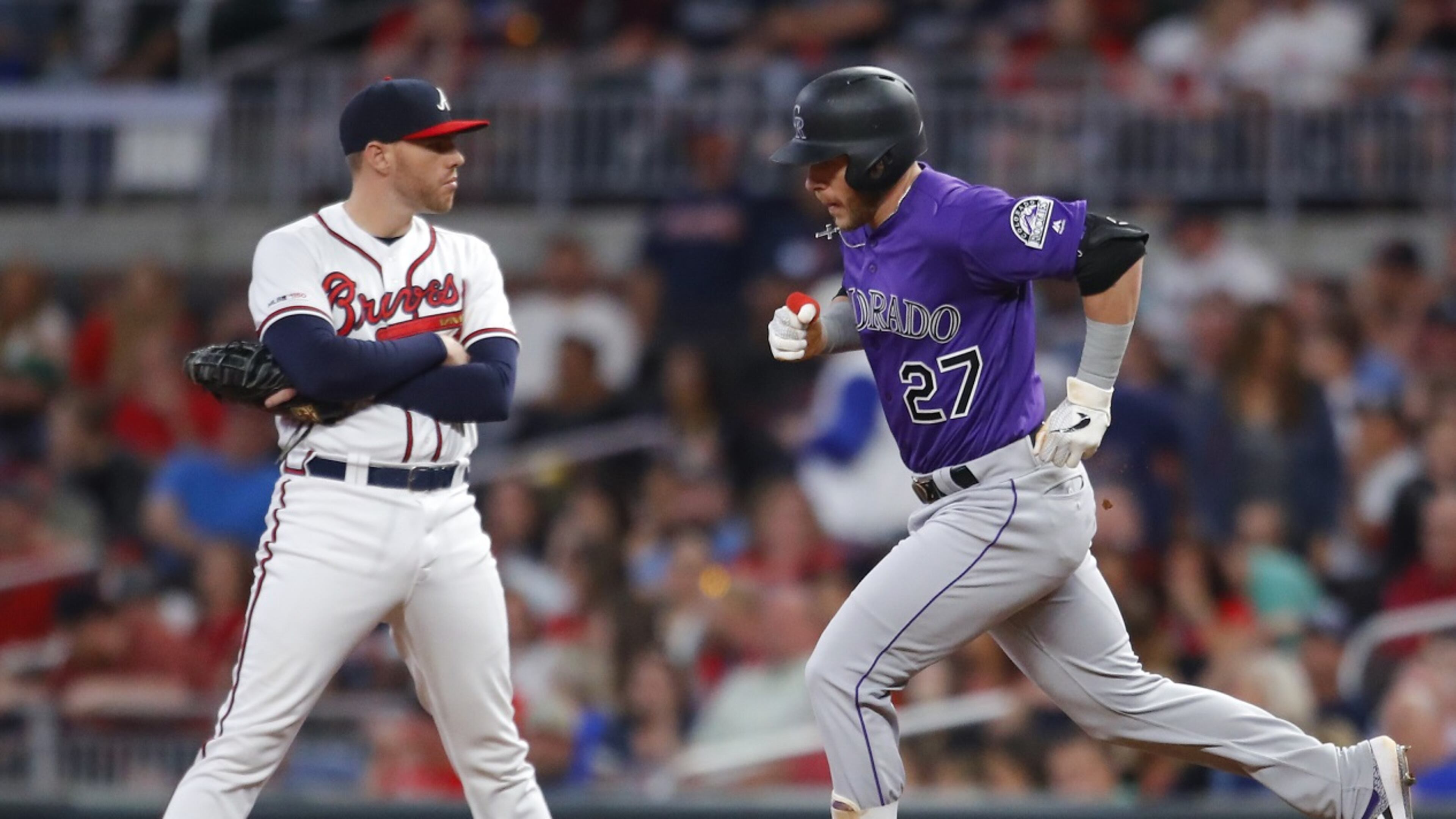 Trevor Story of the Colorado Rockies rounds first after hitting a three run home run as Freddie Freeman #5 of the Atlanta Braves reacts in the ninth inning. (Photo by Todd Kirkland/Getty Images)