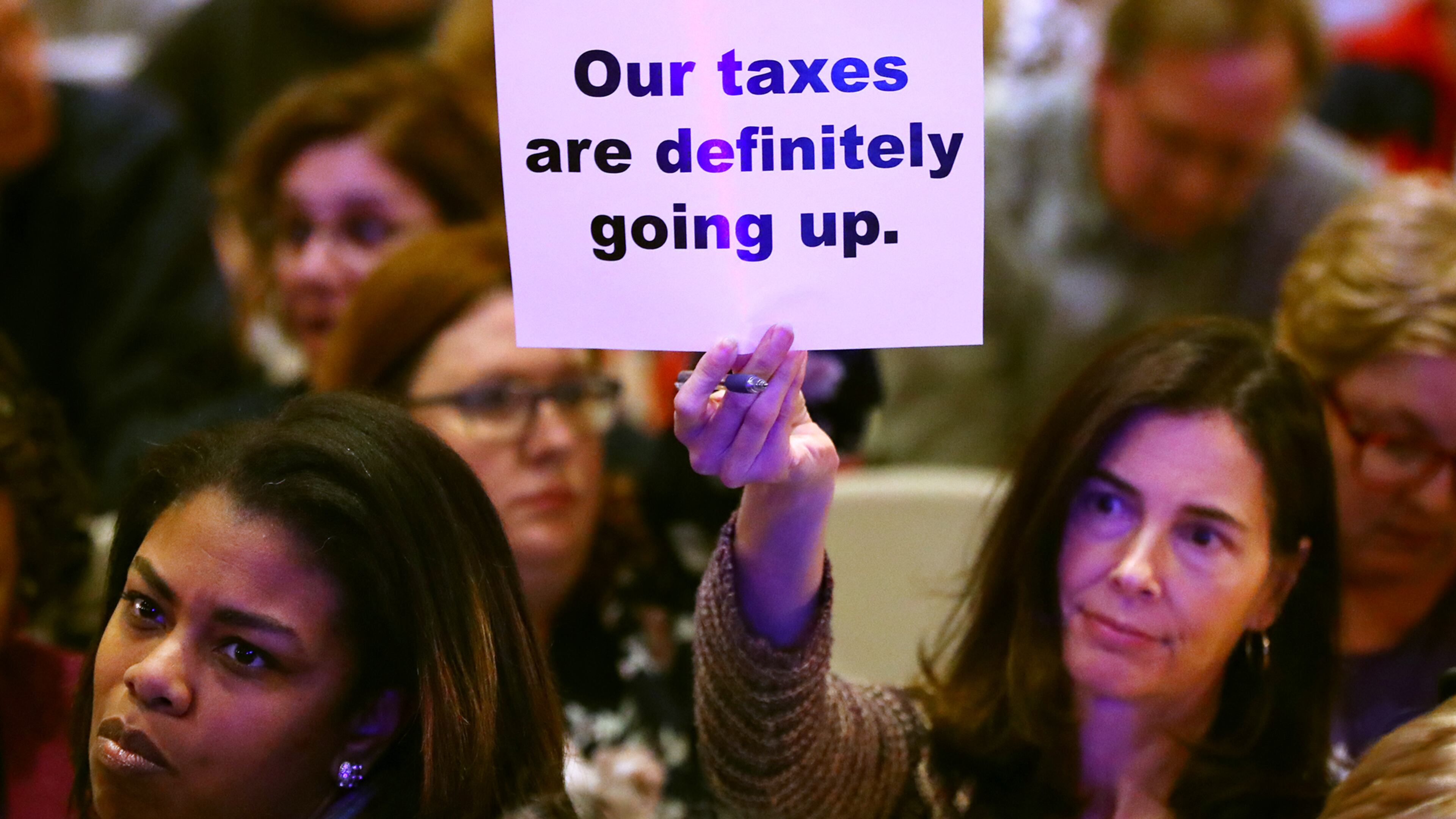 Local resident Patricia Fulton holds up a sign during a town hall meeting on the proposed City of East Cobb in Nolan Hall at the Catholic Church of St. Ann on Thursday, March 28, 2019, in Marietta. Curtis Compton/ccompton@ajc.com