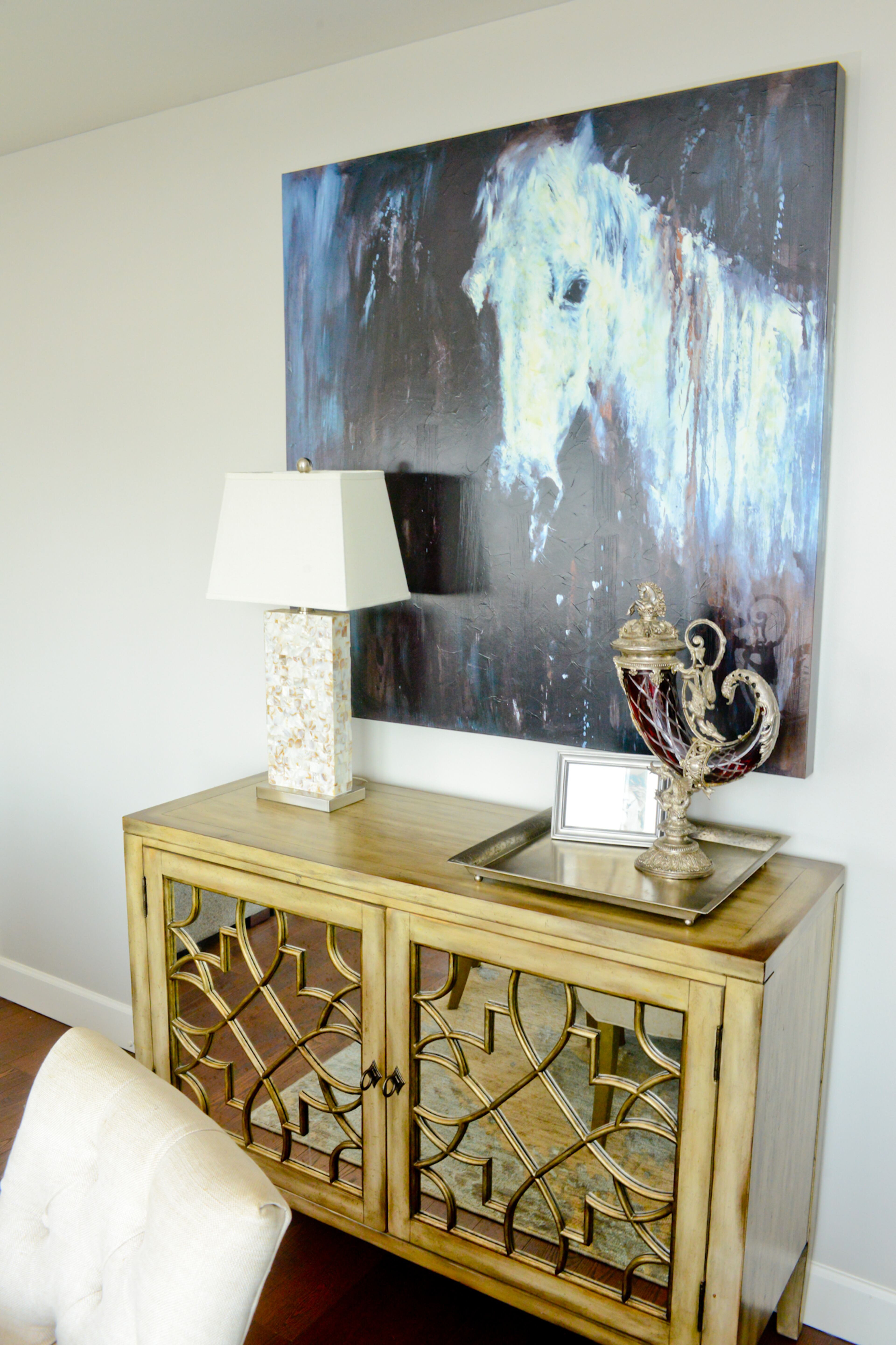 A grayish-wood Hooker dining console, Charles Ray at AmericasMart, features a stylish antique mirrored front. Hanging above the console is one of the many horse paintings by the late Atlanta artist James McLaughlin Way that Johnson showcases in his home.