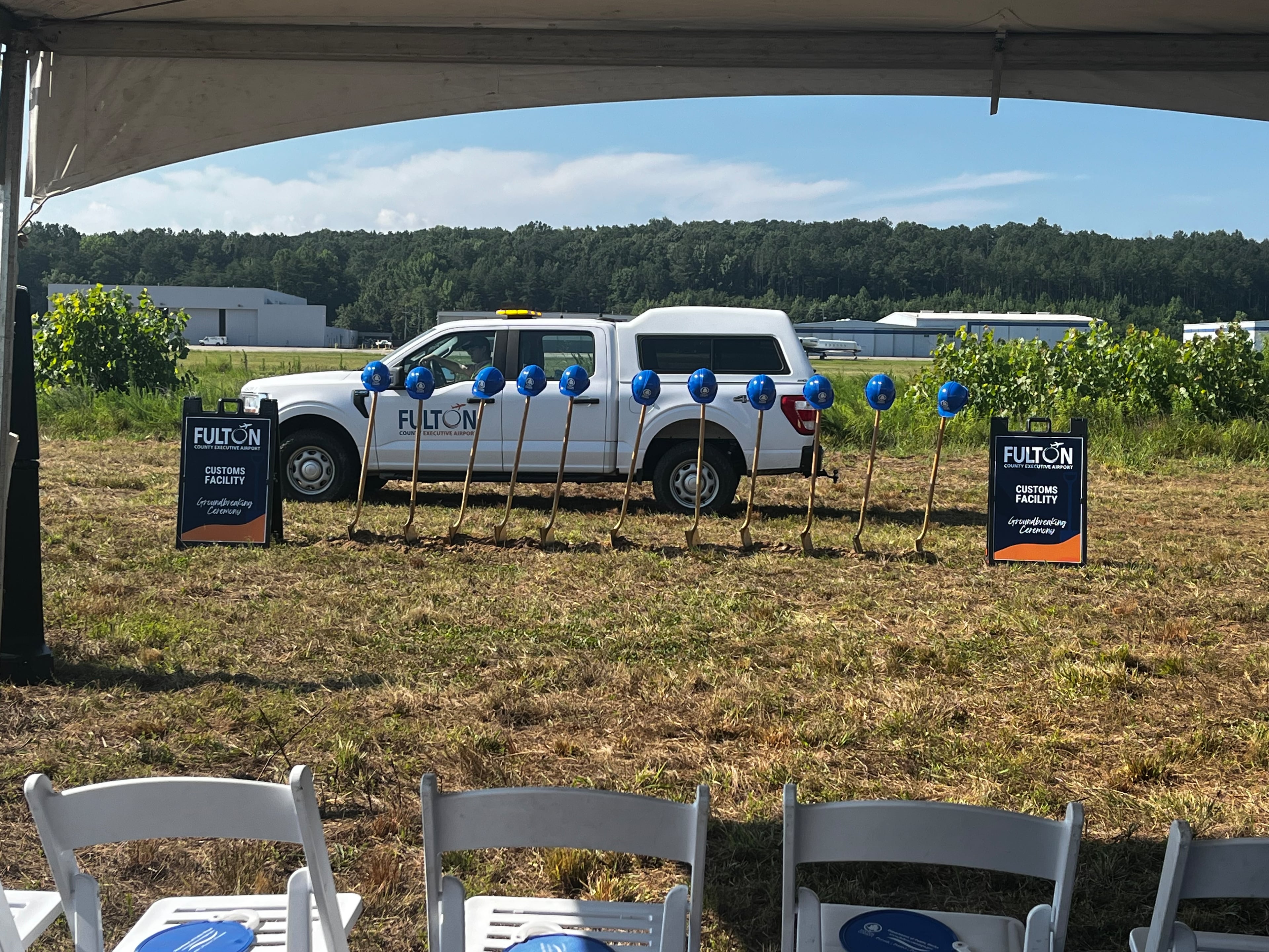 A Fulton County truck drives by before the groundbreaking ceremony for a customs facility at Fulton County Executive Airport. (Carson Bonner/AJC)