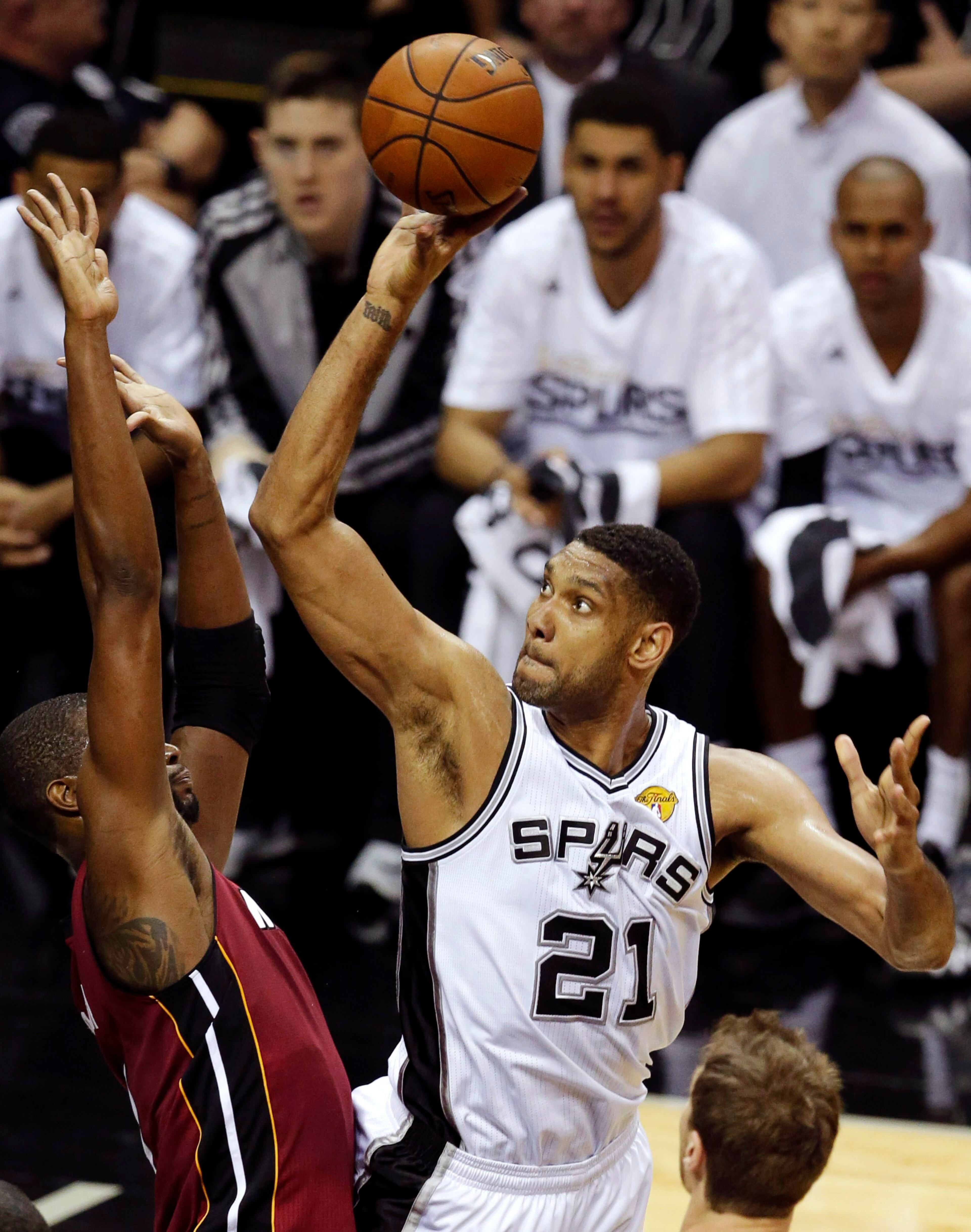 San Antonio Spurs forward Tim Duncan (21) shoots over Miami Heat center Chris Bosh (1) during the first half in Game 1 of the NBA basketball finals on Thursday, June 5, 2014, in San Antonio. (AP Photo/Tony Gutierrez)