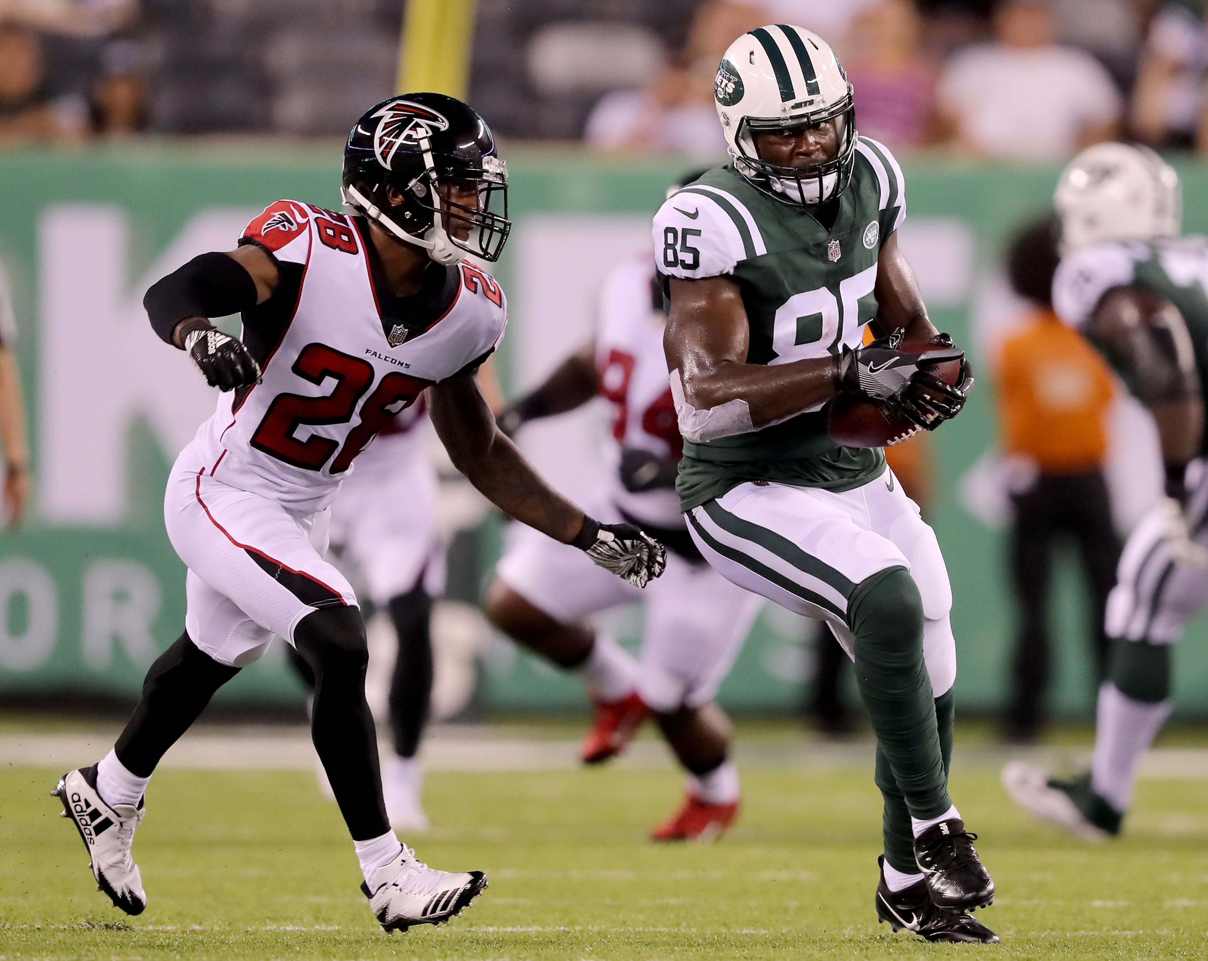 EAST RUTHERFORD, NJ - AUGUST 10: Neal Sterling #85 of the New York Jets makes the catch as Justin Bethel #28 of the Atlanta Falcons defends in the second quarter during a preseason game at MetLife Stadium on August 10, 2018 in East Rutherford, New Jersey. (Photo by Elsa/Getty Images)