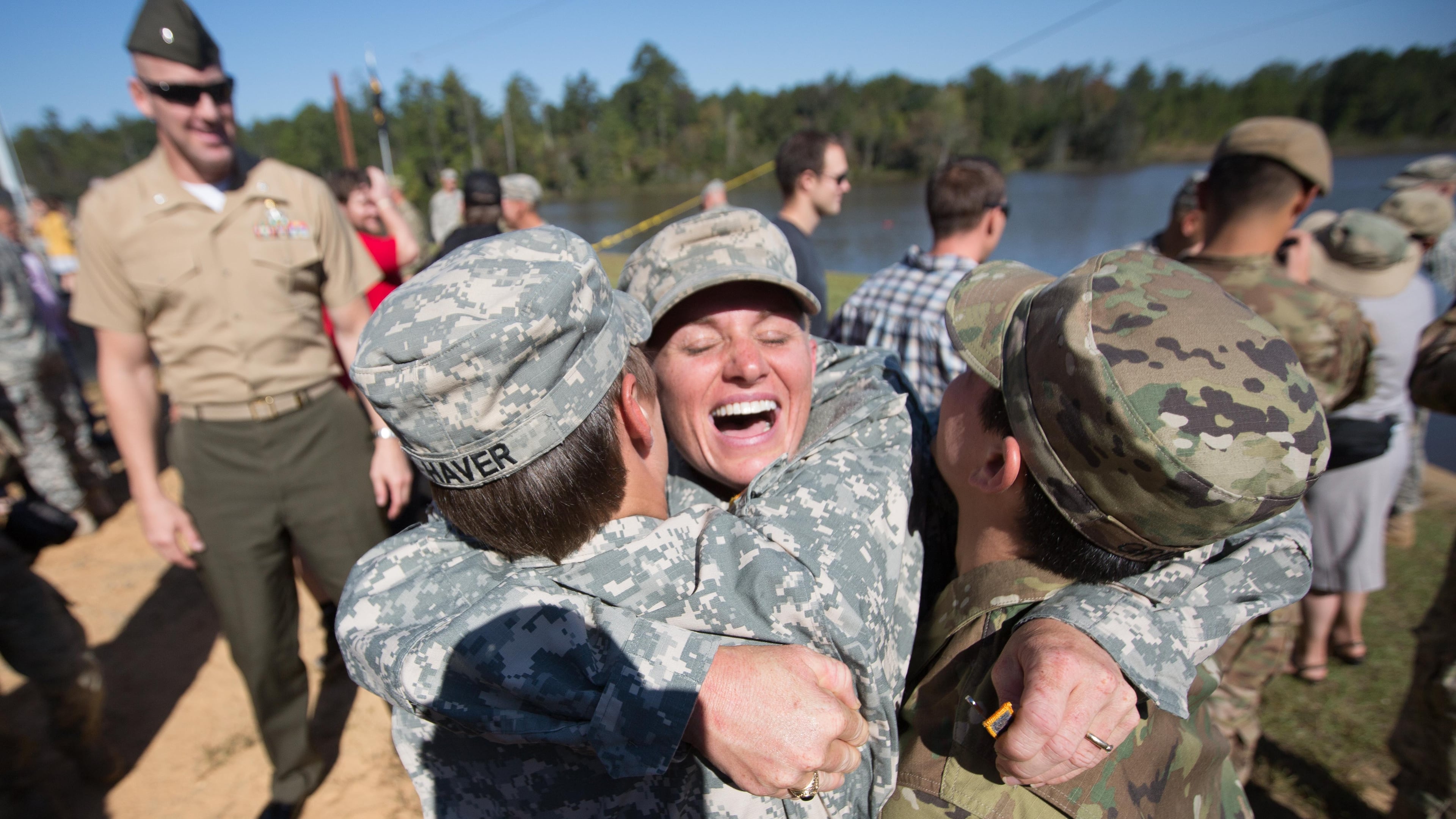 Maj. Lisa Jaster, center, embraces First Lt. Shaye Haver, left, and U.S. Army Capt. Kristen Griest, right, after an Army Ranger School graduation ceremony, Friday, Oct. 16, 2015, in Fort Benning, Ga. Jaster, who is the first Army Reserve female to graduate the Army's Ranger School, joins Griest and Haver as the third female soldier to complete the school. (AP Photo/Branden Camp)