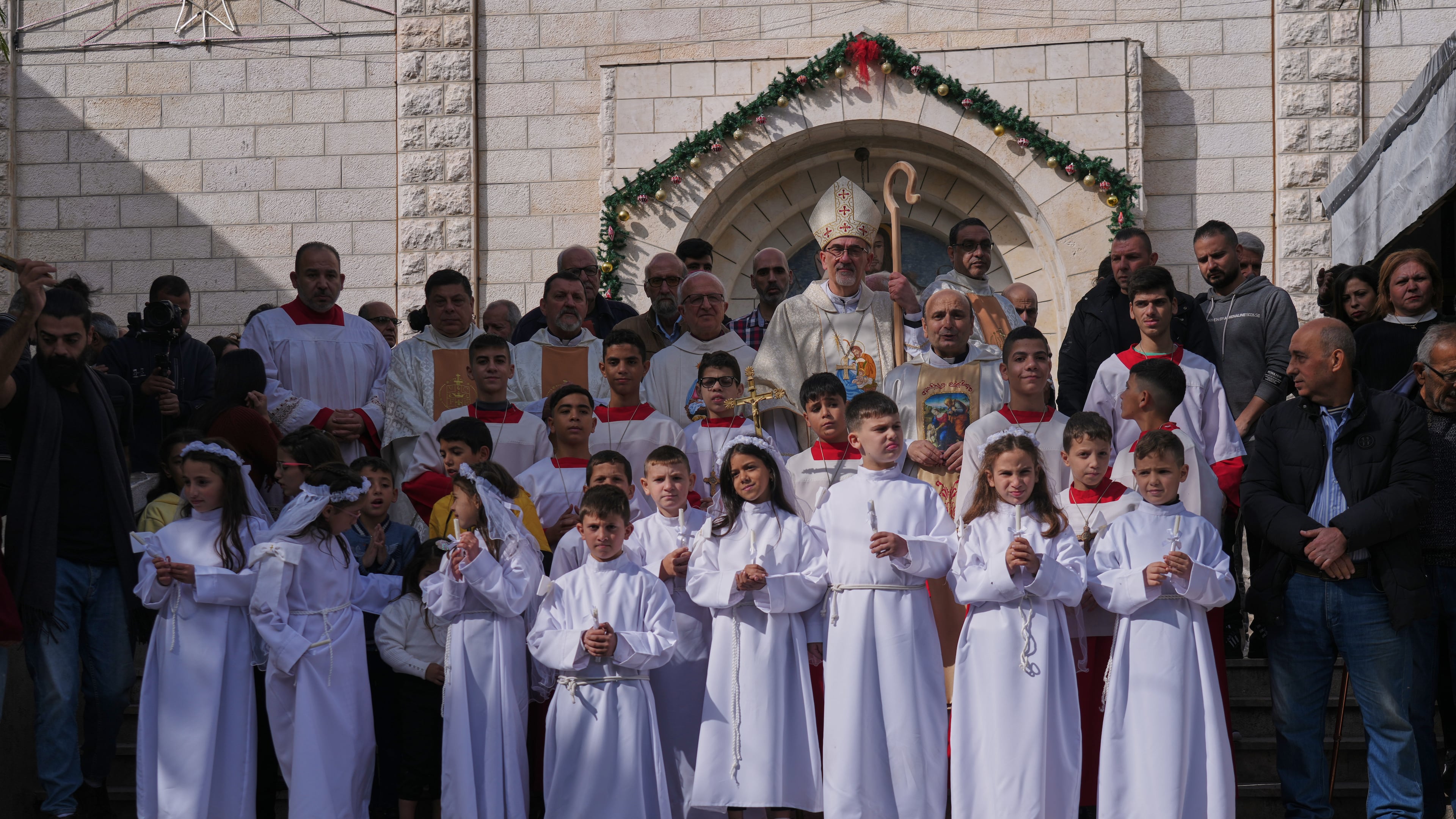 Cardinal Pierbattista Pizzaballa, the Latin Patriarch of Jerusalem, poses for the photos with Palestinian parishioners after leading a mass ahead of Christmas celebrations at the Holy Family Catholic Church in Gaza City, Sunday, Dec. 21, 2025. (AP Photo/Jehad Alshrafi)