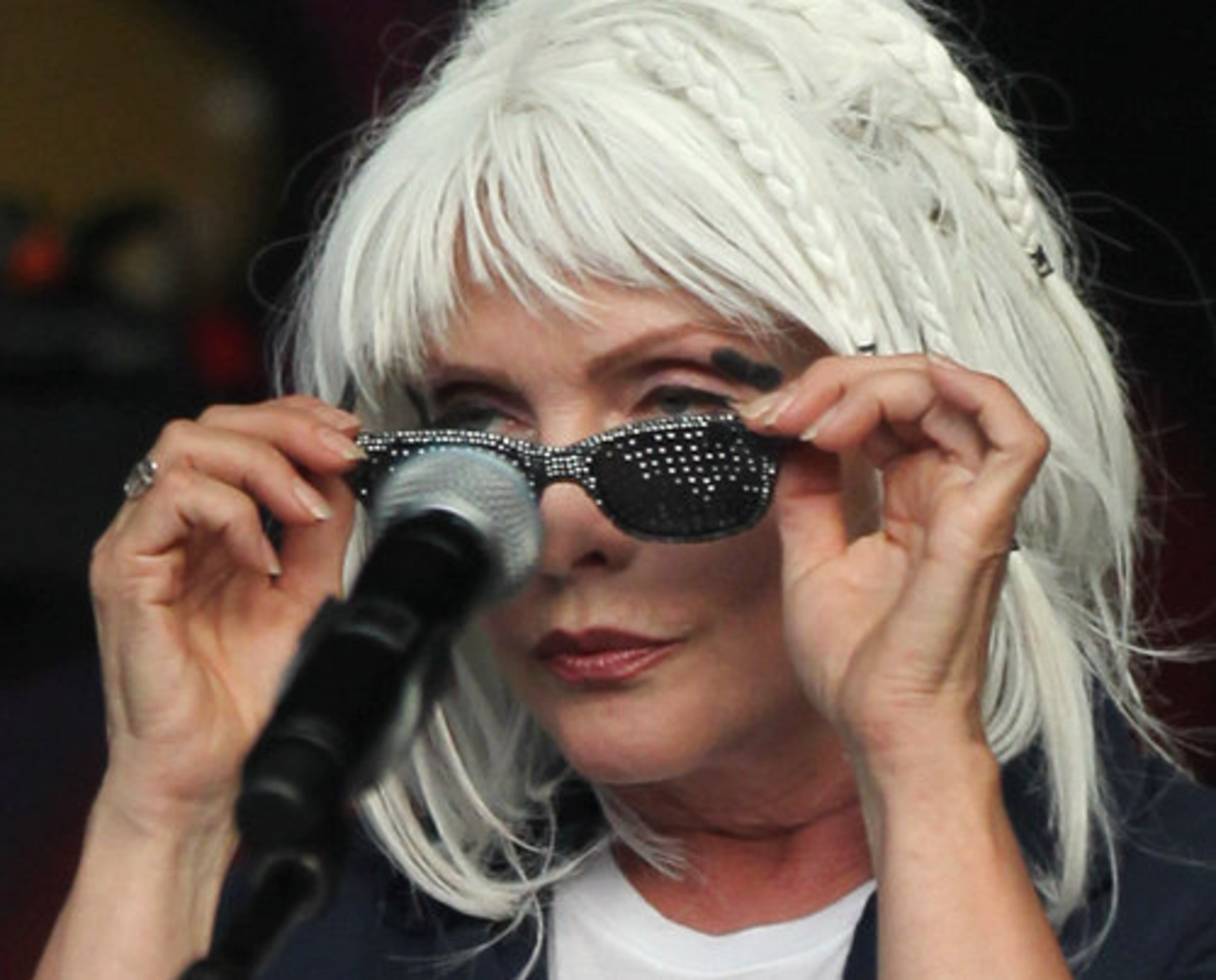 Singer Debbie Harry takes off her sunglasses as she performs. Blondie has sold 40 million records worldwide and is still active performing with a new album, Panic of Girls.