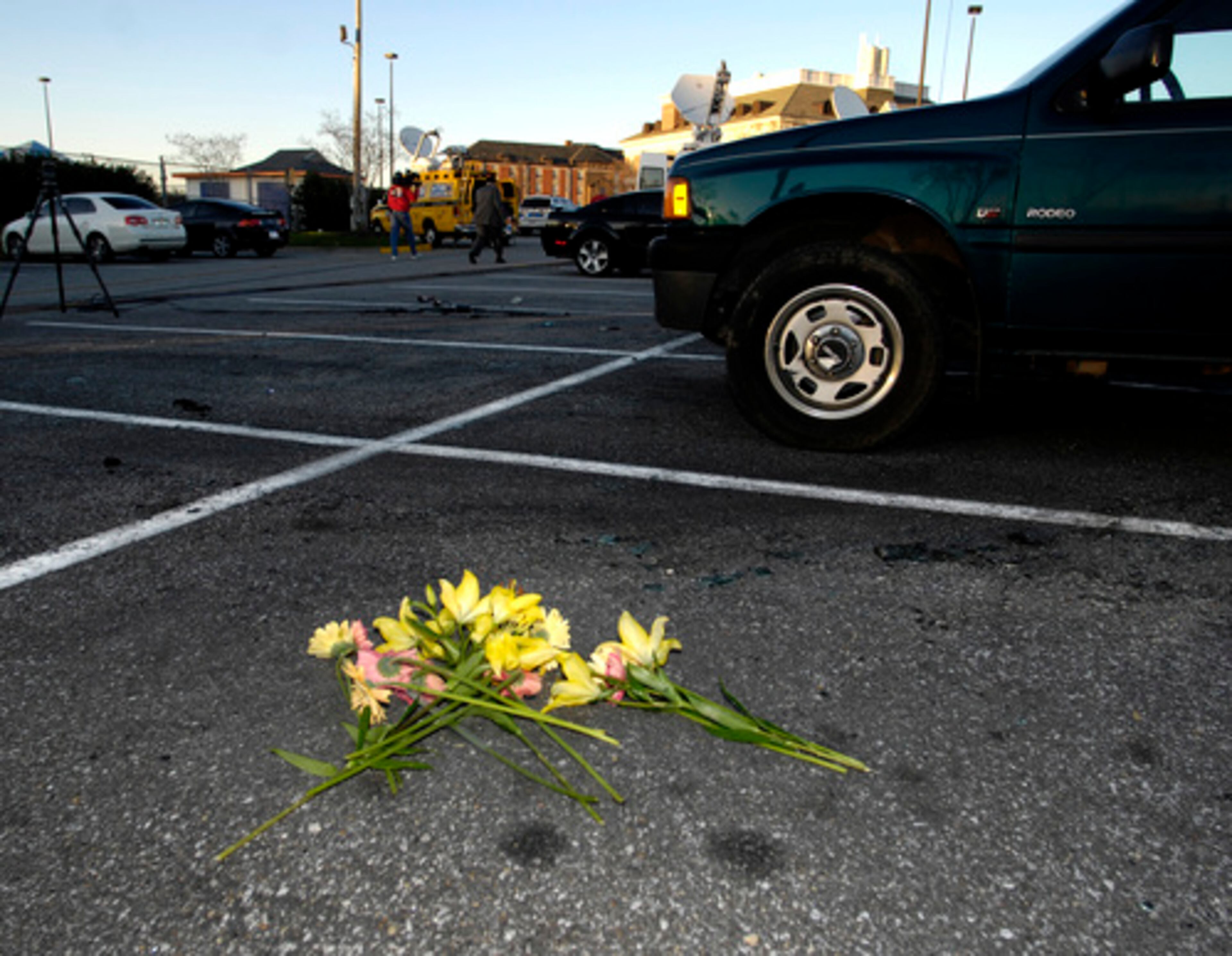 Flowers lie near the parking spot where Burk's car was found ablaze Monday night.