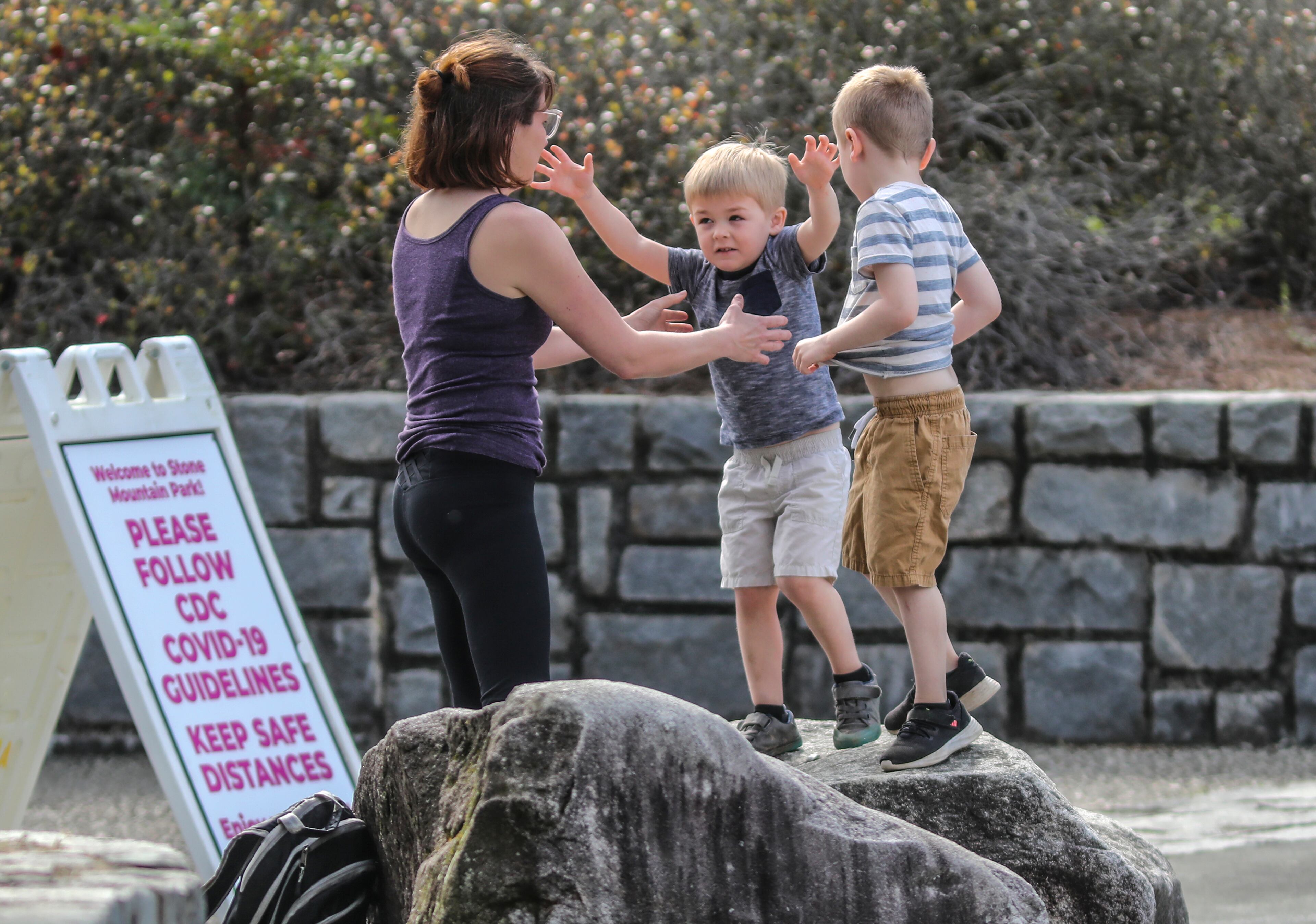March 27, 2020 Stone Mountain Park: Left to right- Ruth Ann North and sons, Andy-3 and Jack-5 wait for husband/dad, Ian to get back from his run on Friday, March 27, 2020. The Chamblee family usually visits the park twice a month but trips have been more frequent because of their closed local parks. Stone Mountain Park has signs placed throughout the park reminding visitors about social distancing as its attractions are closed, but nature trails open. Signs are popping up everywhere related to Covid-19. Georgia is under a particularly brutal siege from the novel coronavirus, a situation unlikely to end for weeks, or even longer. Only five states have reported more deaths than Georgia from COVID-19, the disease caused by the coronavirus, according to the latest available data. And even though the state has tested only the sickest patients, excluding those who exhibit no severe symptoms of the disease, Georgia still ranks 10th nationally in confirmed cases. Georgia Gov. Brian Kemp pleaded with Georgians during a Thursday statewide televised event to stay home and practice social distancing even as he stressed more drastic measures weren't yet needed to stem the disease's spread. Georgia's confirmed coronavirus cases soared past 1,600 on Thursday, roughly doubling the numbers reported by state health officials just four days ago. Over the past two weeks, the disease has claimed the lives of at least 56 Georgians. Kemp on Thursday ordered k-12 public schools shut down through April 24 though he stopped short of canceling schools through the end of the year. JOHN SPINK/JSPINK@AJC.COM