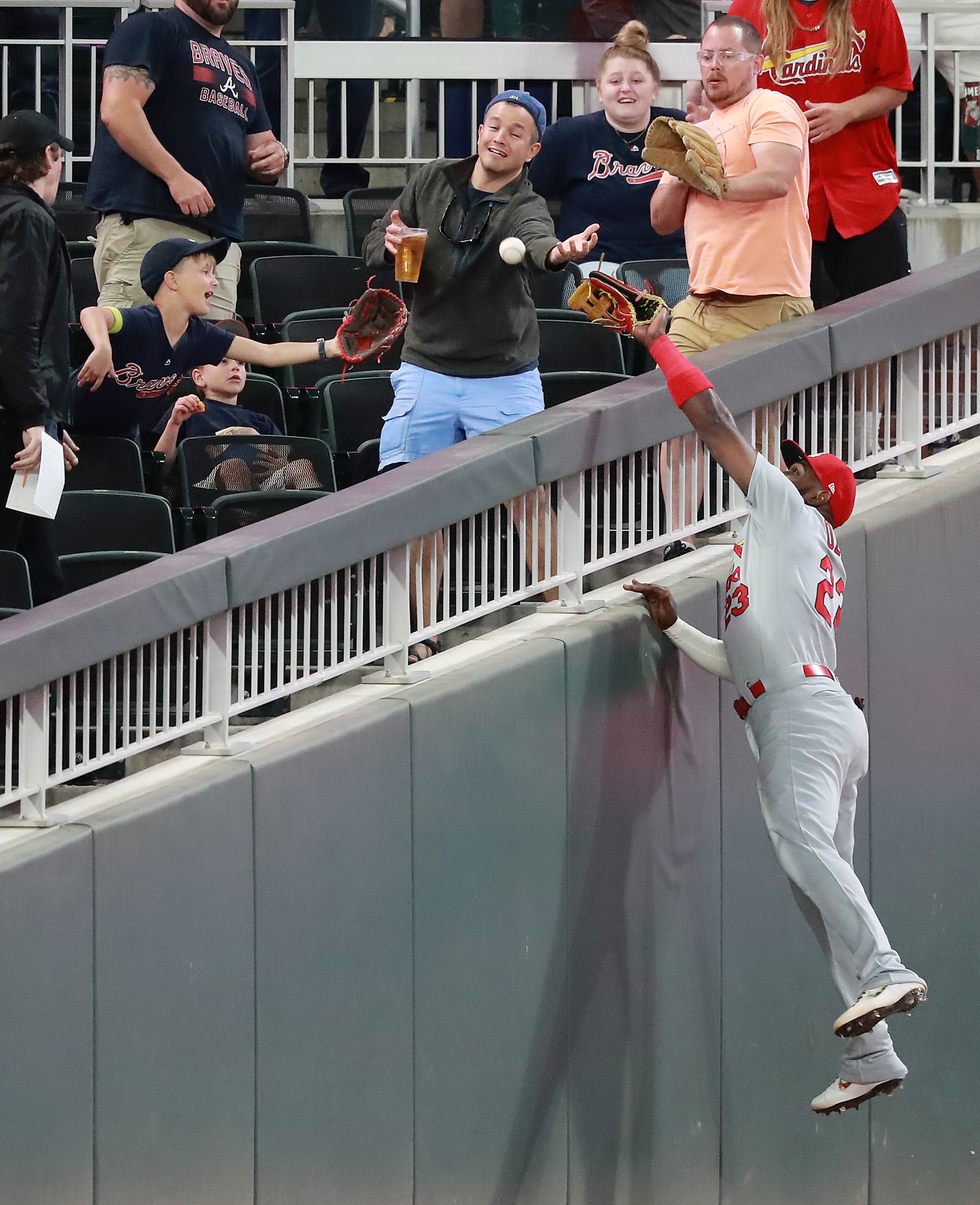 Cardinals outfielder Marcell Ozuna goes to the wall but can't quite reach a foul ball by Braves' Johan Camargo. Curtis Compton/ccompton@ajc.com